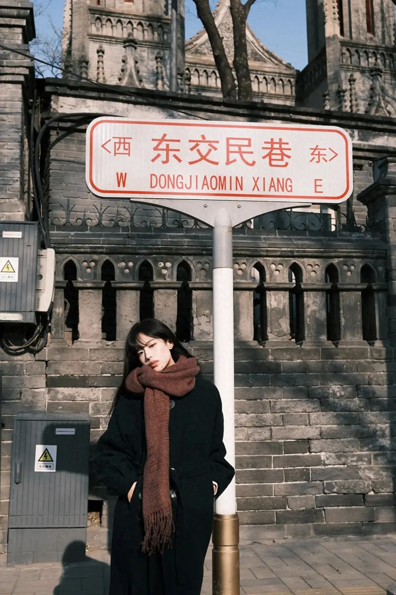 Under the premise of ensuring safety, the model stands on one side of the road sign while the photographer stands on the double yellow solid line in the middle of the road, zooming the lens to 1.5 times, with the subject occupying the middle and bottom two-thirds of the frame.

Equipment settings: Fujifilm XT30II, lens 18-55.

Photography pose: Leaning against the road sign, slightly tilting the head, and not looking at the camera.