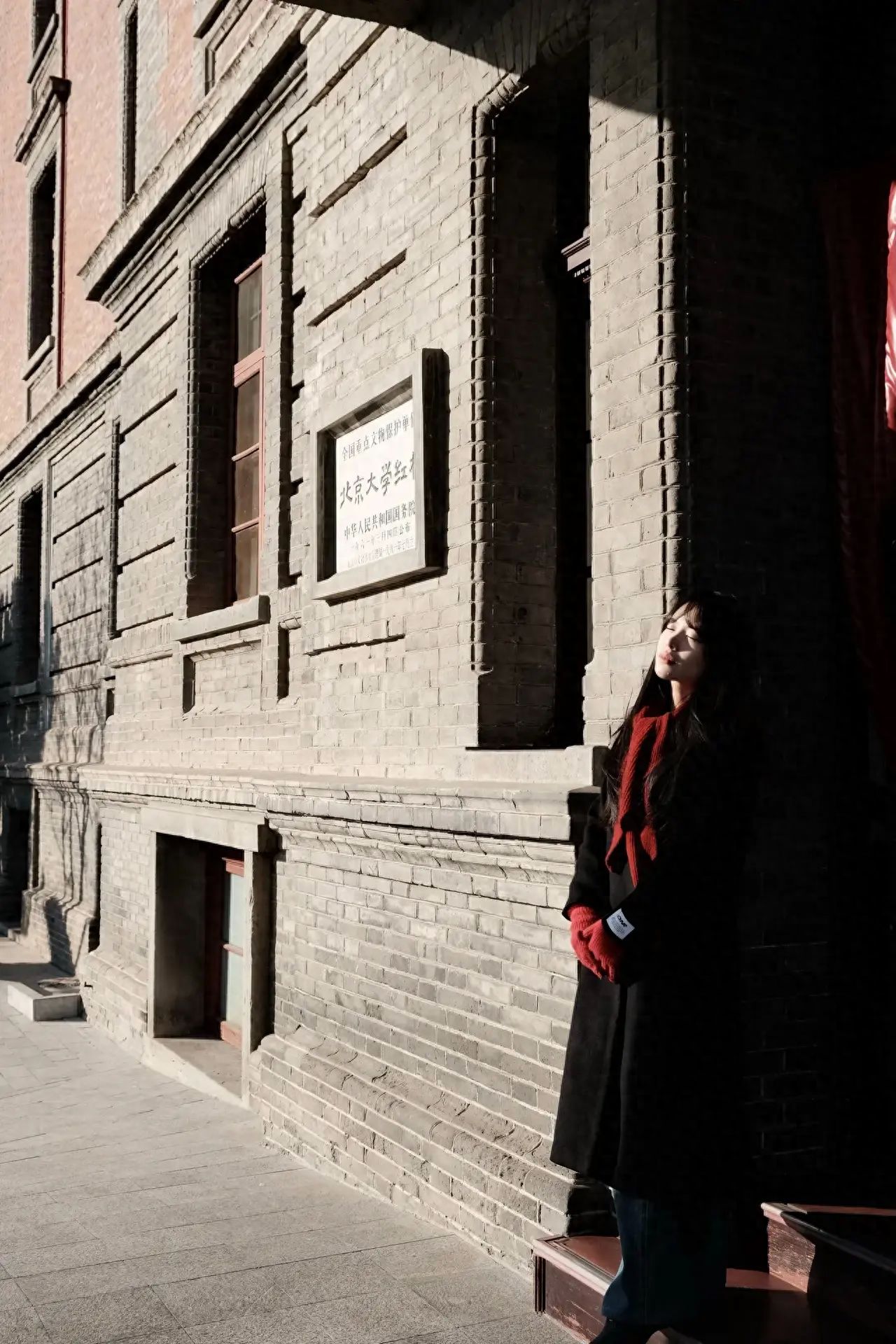 The model stands at the entrance steps of the building, while the photographer stands in front of the pillar opposite, suggesting to frame the white sign of the Peking University Red Building, as well as the wooden red windows next to it for the shot.

1. Equipment settings: Fuji XT30II, lens 18-55.
2. Post-processing: It is recommended to adjust the color, contrast, and sharpness through post-processing software to make the photo more textured.
3. Ticket price: Free, but reservation is required.