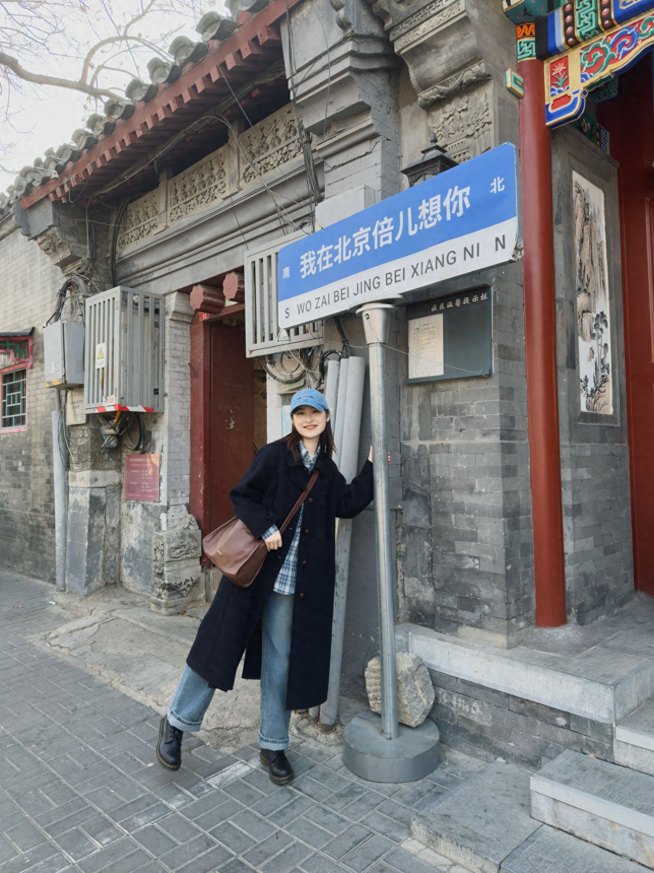 The models stand on either side of the sign, with the photographers positioned face-to-face, 2 meters apart, using a 50mm focal length to capture the sign in full. The model stands in front of the sign, stretching both arms upward, lifting one leg to the side, smiling at the photographer, holding the round bar below the sign with one hand making a victory sign, and standing with legs in a staggered position, looking askance at the photographer.