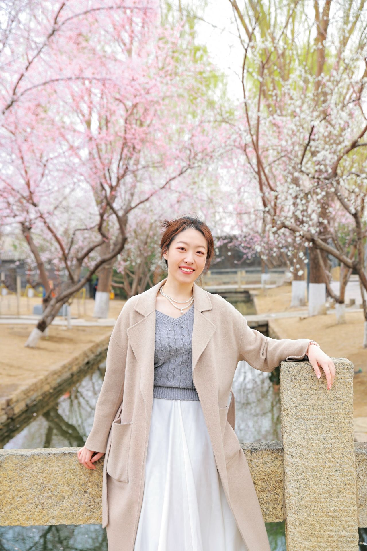 The photographer and the model should be at the same height, approximately 2 meters away from the model, only capturing the upper body and avoiding cluttered backgrounds. It would be more visually appealing with peach blossoms as the backdrop.

Photo Pose: The model can rest their hand on the stone railing for a more relaxed feel.

Shooting Time: March 15th, 10:30 AM

Shooting Equipment: Canon R6 with a 24-70mm lens.