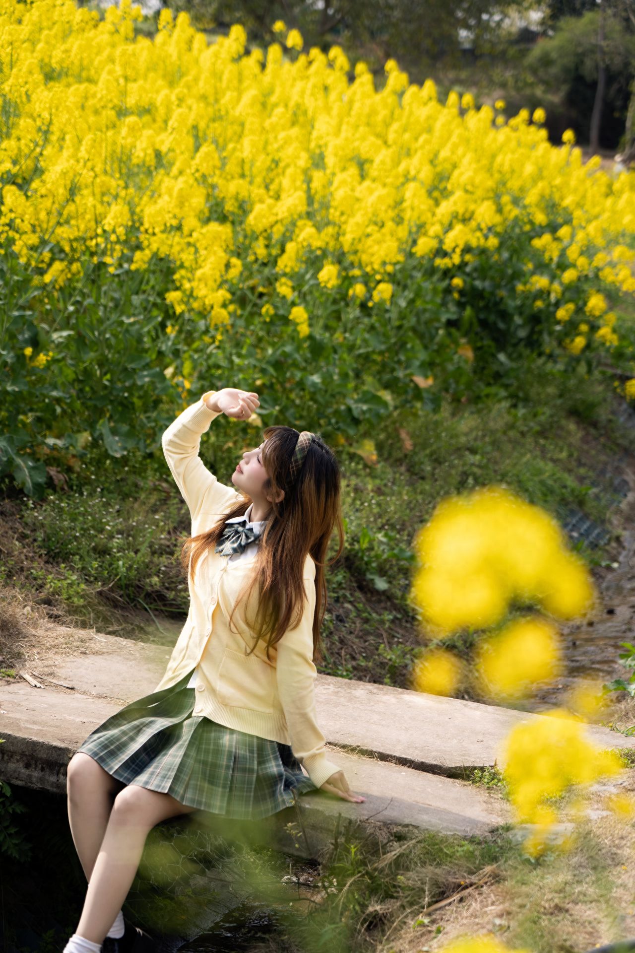 The model sits on a stone slab, and the photographer uses rapeseed flowers as the foreground, with the rapeseed flower cluster and sky as the background to enrich the image. It is recommended to use a large aperture and appropriately increase the exposure to make the picture more vivid.

1. It is suggested to shoot between 3:00 PM and 5:00 PM for better lighting and more impressive photos.
2. It is recommended to drive yourself for more convenience.
3. It is advised to wear light-colored clothes to match the rapeseed flowers better.