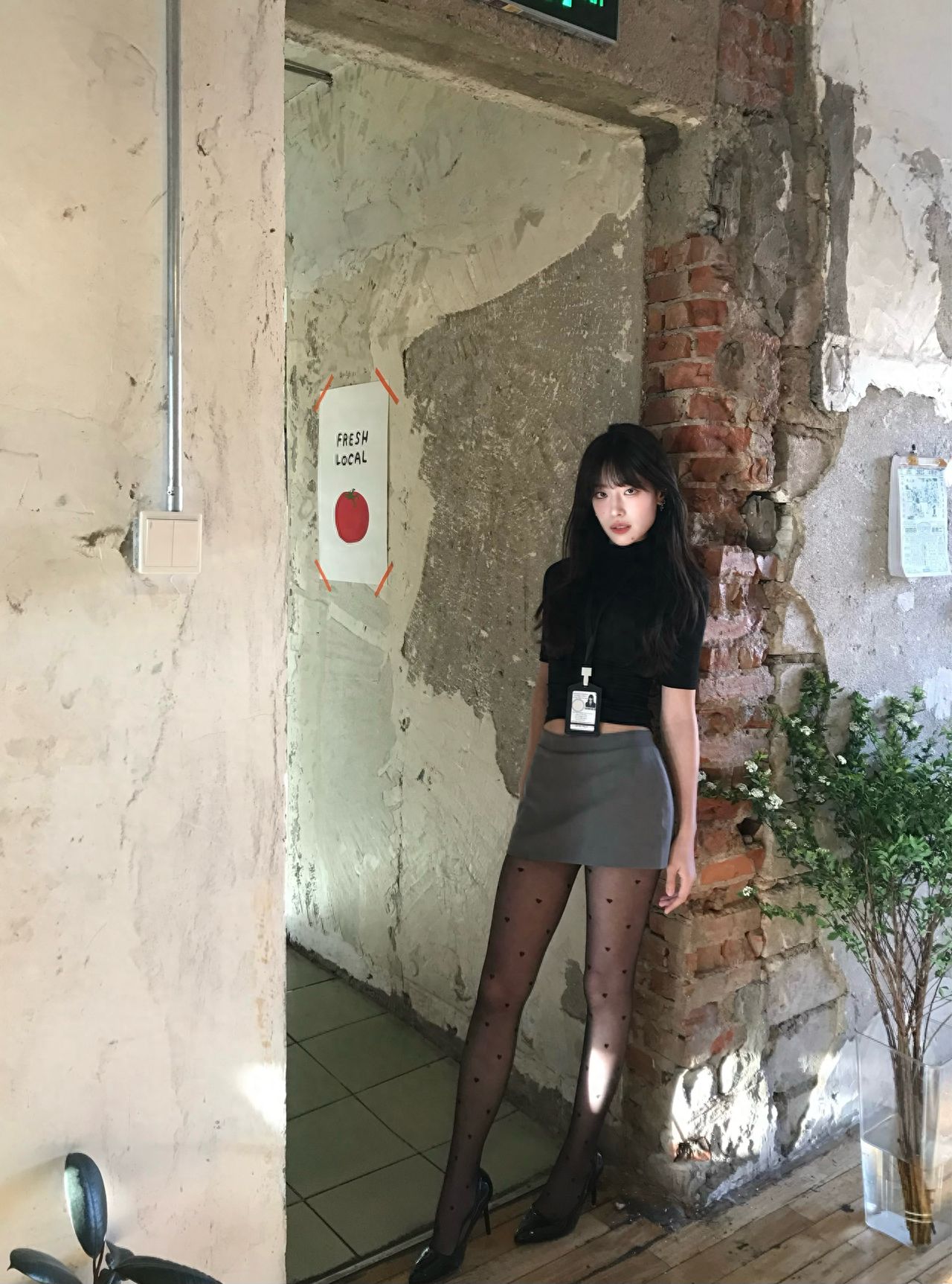 The model leans against the wall, and the photographer shoots from a diagonal side about 2 meters away, holding the phone lower and tilting it towards their body to capture long legs. The background wall and door frame naturally divide the frame. Use a 50mm lens for a camera or 2x zoom on a phone to avoid distortion caused by wide-angle lenses.

1. Equipment Information: iPhone7.
2. Dressing Advice: Korean-style, casual wear.
3. Additional Experience: Approximately 44r per person.