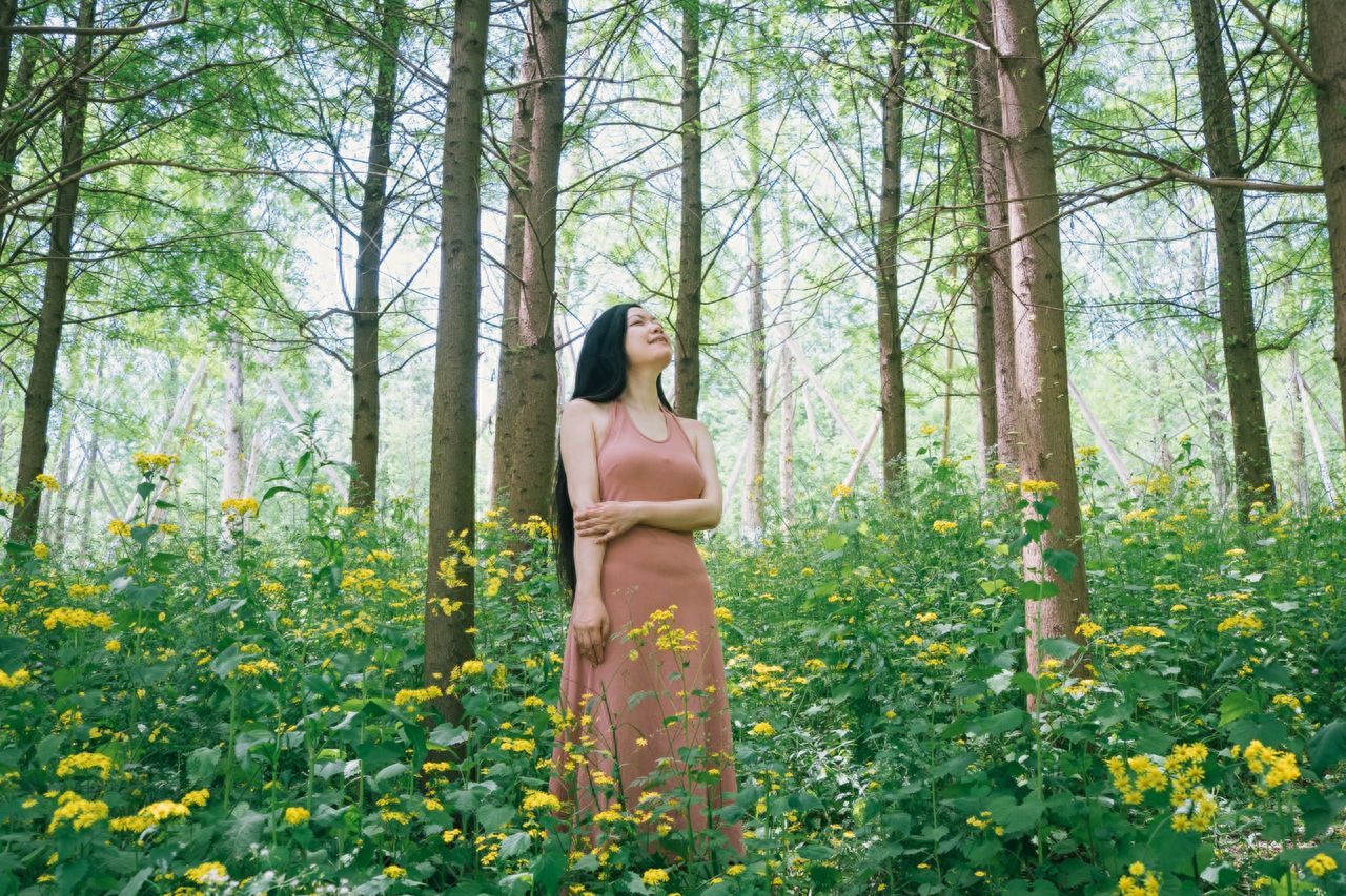 With the dandelion flowers and bald cypress as the foreground or background, the person stands among the flowers or on the path for a photo.

Photo pose: The model stands naturally with hands crossed in front or behind, slightly turning or tilting the head back to create an atmosphere of elegance and relaxation.