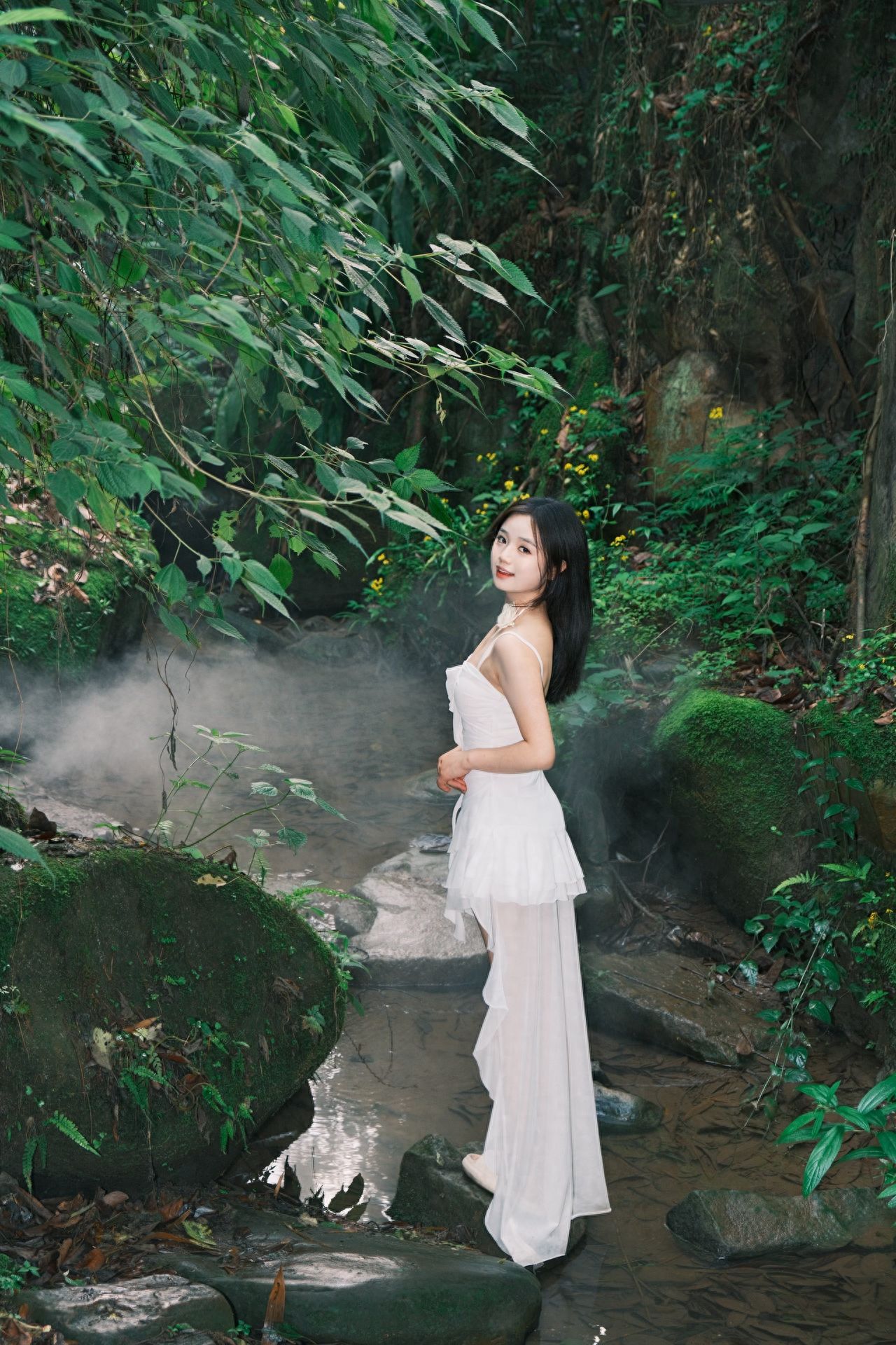 The model stands on the rocks by the stream, with the photographer about 1 meter away from the model, maintaining a horizontal shooting angle to highlight the character in the natural environment. Using the rule of thirds composition, the model is placed on the right third of the frame, with green plants on the left to create a sense of depth.

1. Shooting equipment: Fujifilm X-H2 camera, 18-55mm lens.
2. Photo poses:
   ① Side view, hands in front, smiling at the camera;
   ② Back view, hands raised high and open;
   ③ Back view, hands in front;
   ④ Back view, left hand straight behind the back, right hand holding the left hand.
3. Other tips: It is recommended to bring a flash, mosquito repellent, and mosquito patches, and avoid wearing shoes with heels.