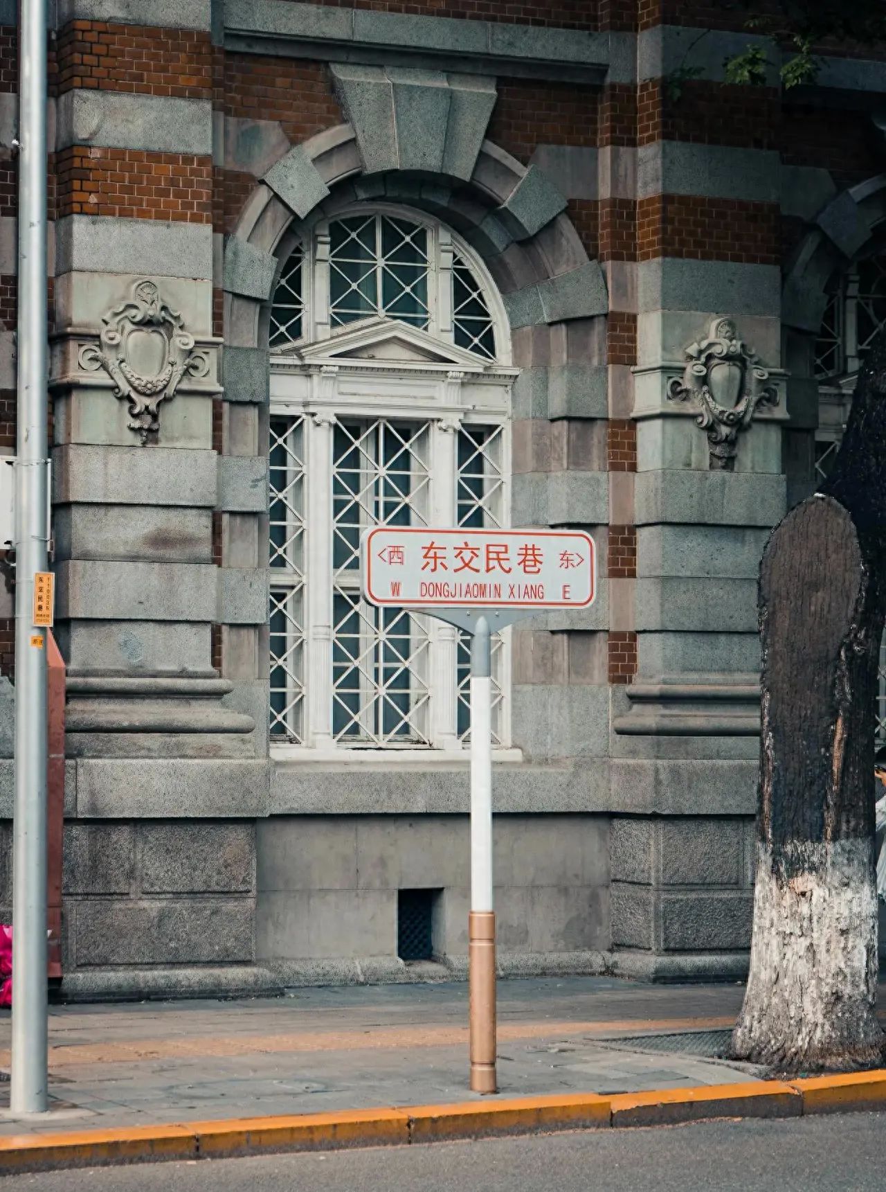 The photographer stands parallel to the sign and building, capturing the scene from a slight distance with a direct line of sight, employing a framing composition technique. By using the architectural arches and windows as frames, the sign is incorporated, enhancing the sense of depth in the image.

1. Travel tips: It is recommended to take photos after 3 PM when the light is softer, resulting in a better atmospheric feel in the photos.

2. Wardrobe suggestions: It is advised to wear simple vintage French or American-style clothing, which matches the architectural style more effectively.