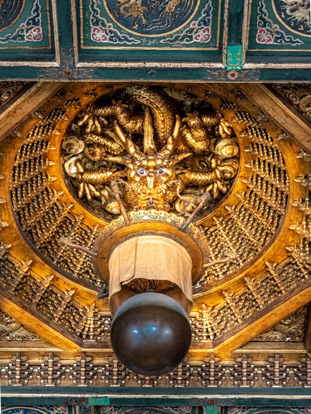 Adopting central symmetry composition, with the golden dragon ceiling at the core, decorative patterns and lighting fixtures are symmetrically distributed along the central axis. By utilizing the intricate details of golden carvings and symmetrical layout, the visual focus is strengthened, showcasing the exquisite craftsmanship and solemn beauty of ancient architectural decorations, and conveying the symmetrical aesthetics of traditional construction.

Equipment information: Use a small aperture with a telephoto lens for shooting.

Travel tips: It is recommended to visit at noon for better lighting.