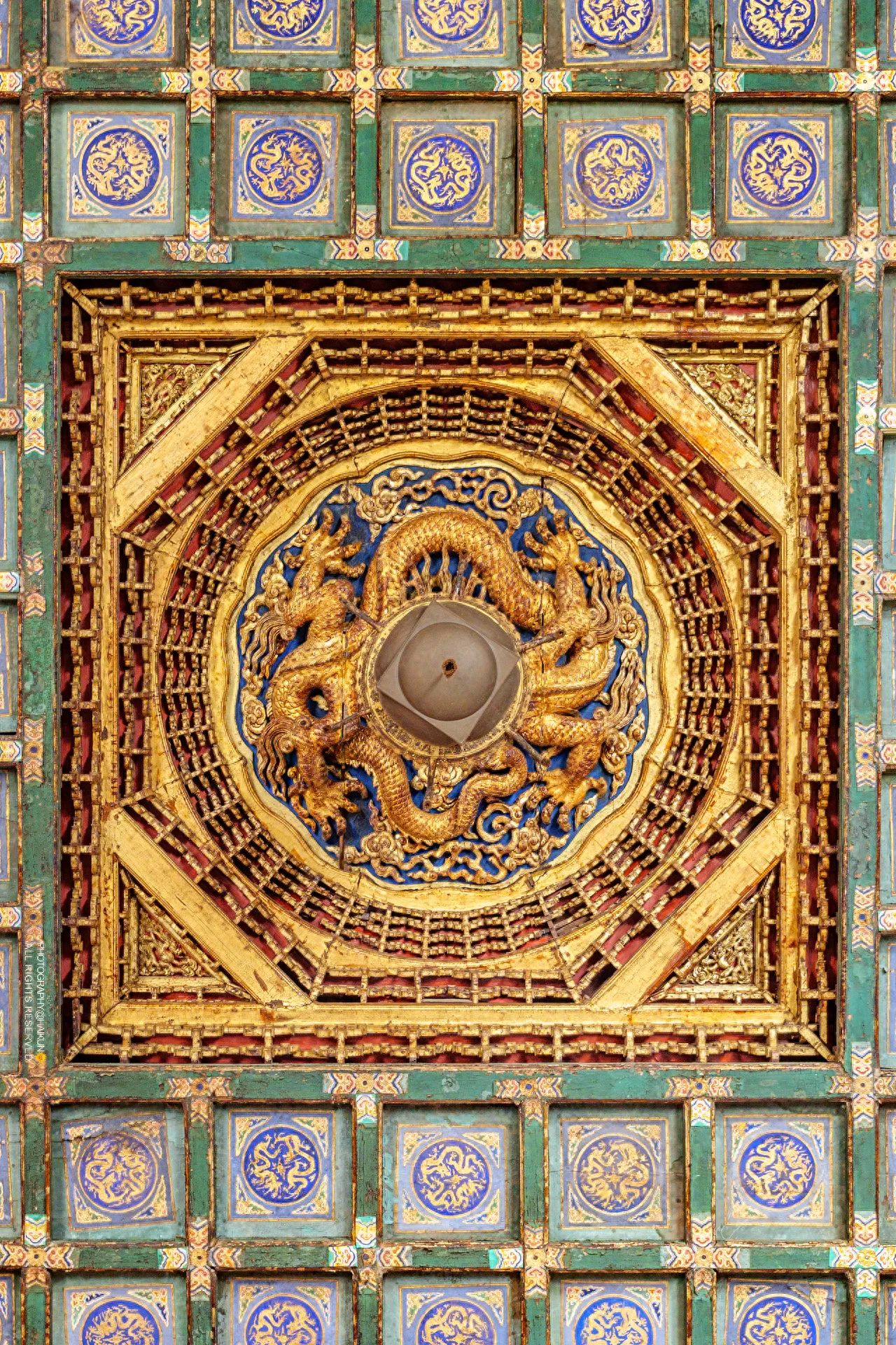 The photographer is positioned directly below the ceiling of the Hall of Benevolence and Longevity, using a low-angle shot with a symmetrical composition, centered around the axis of the ceiling with decorative patterns strictly symmetrically distributed.

1. Travel Tips:
   - Ticket Price: 60 yuan;
   - Opening Hours: 8:30-17:00, closed on Mondays.
2. Dressing Suggestions: It is recommended to wear Hanfu or Qipao.