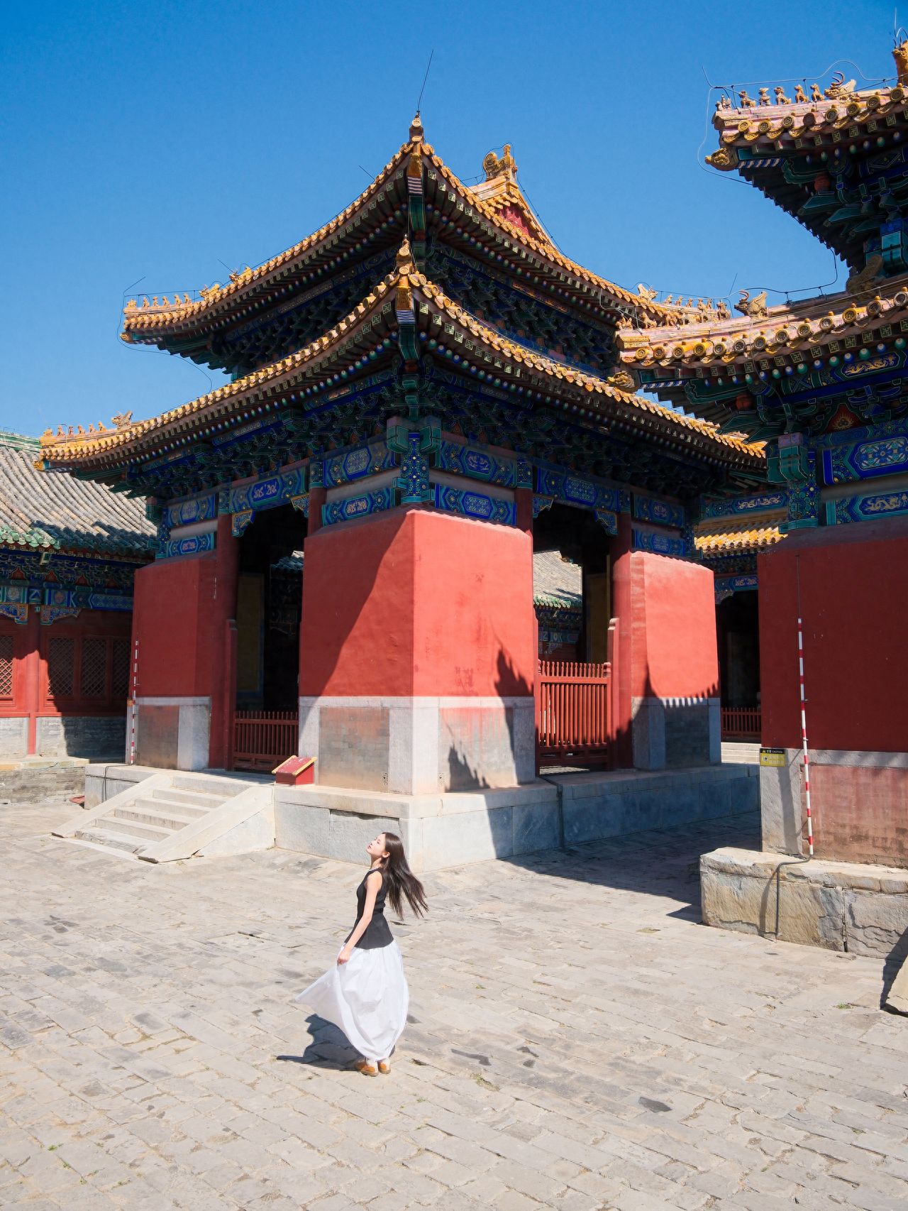 Photo by Confucius Temple and the Imperial Academy Museum - in front of the vermilion walls and golden-tiled architecture.