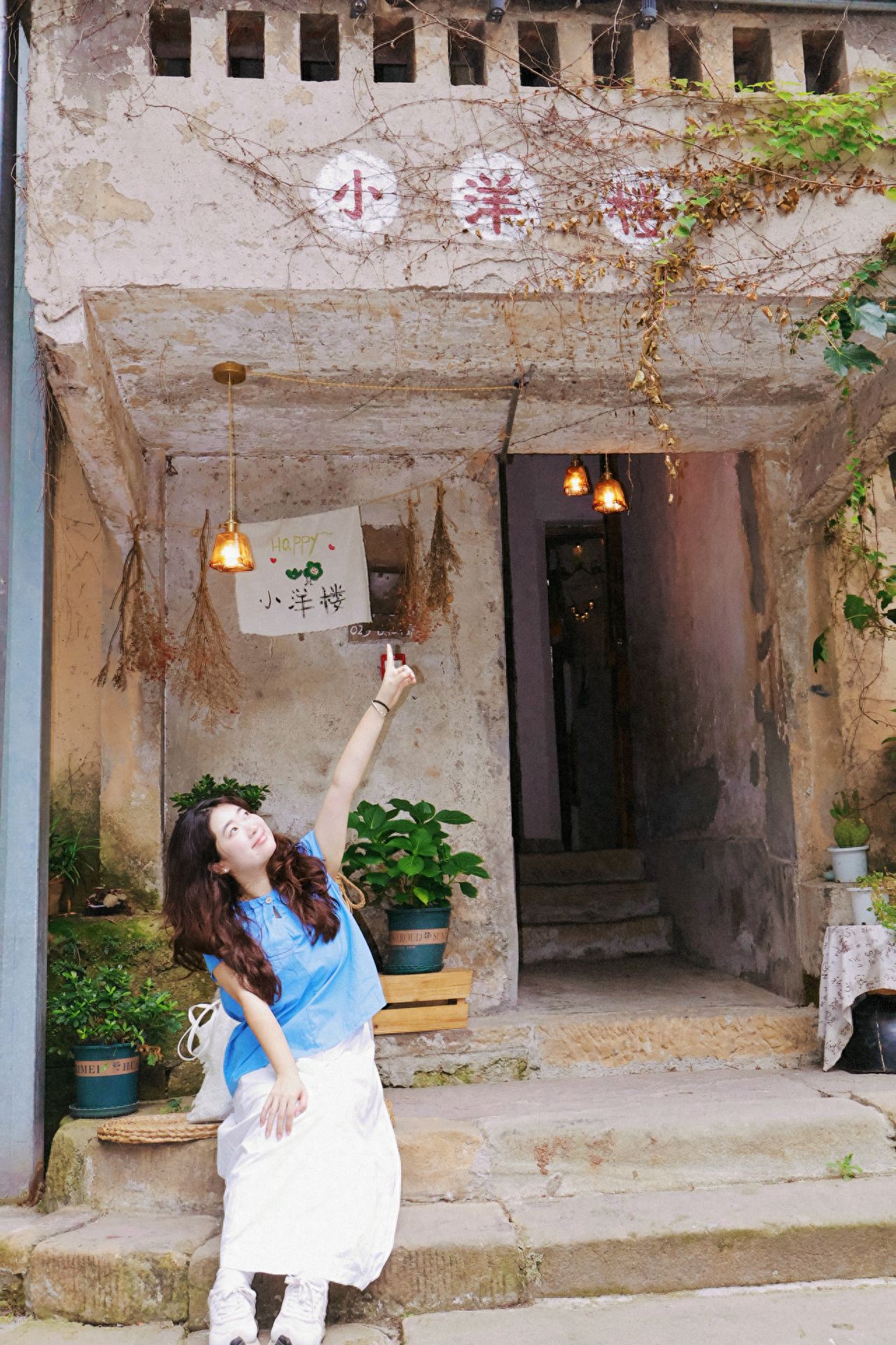 1. The model sits quietly on the steps of the small Western-style building, legs together, hands gently resting on knees, with a straight back. This posture fits the artistic and tranquil atmosphere of the ancient building, as if listening to the stories of the building's years, blending into the scene with a composed posture, conveying a sense of "slow time in the ancient village."

2. The model sits sideways on the steps, one arm stretched up pointing to the "Small Western-style Building" sign, body slightly leaning, and eyes following the fingertips, actively interacting with the check-in location. By using the "pointing" action, the connection with the building is strengthened, adding a lively sense of "discovering a treasure corner" to the image, breaking the static dullness.

Check-in tips:
Come in spring or summer when the ivy is lush, and green vines cover the walls, making the image more vibrant; in the morning or evening, the light is soft, suitable for portrait photography!

Photography tips:
Stand below the steps of the small Western-style building and shoot an upward angle of "people + the entire building" to highlight the ancient architecture and the layered greenery surrounding it; or use the windows of the building as a frame, with the person standing by the window, and let the greenery outside the window serve as the background to create a cinematic image.
