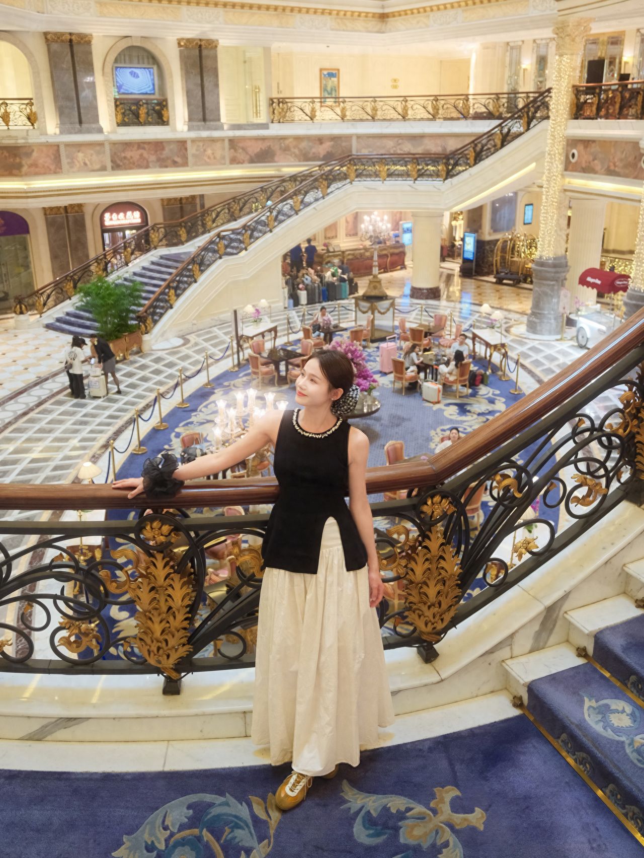 The model stands by the railing on the 1.5-level platform, while the photographer stands on the 2nd level, approximately 5 meters away from the model, with the lobby as the backdrop, capturing from a slightly elevated angle.

1. Photography equipment: Fujifilm XT5 with a 16-50mm lens.
2. Pose: The model leans back against the railing, with one hand extended and resting on it, looking to the side.
3. Visiting suggestion: Free of charge, open 24 hours a day.