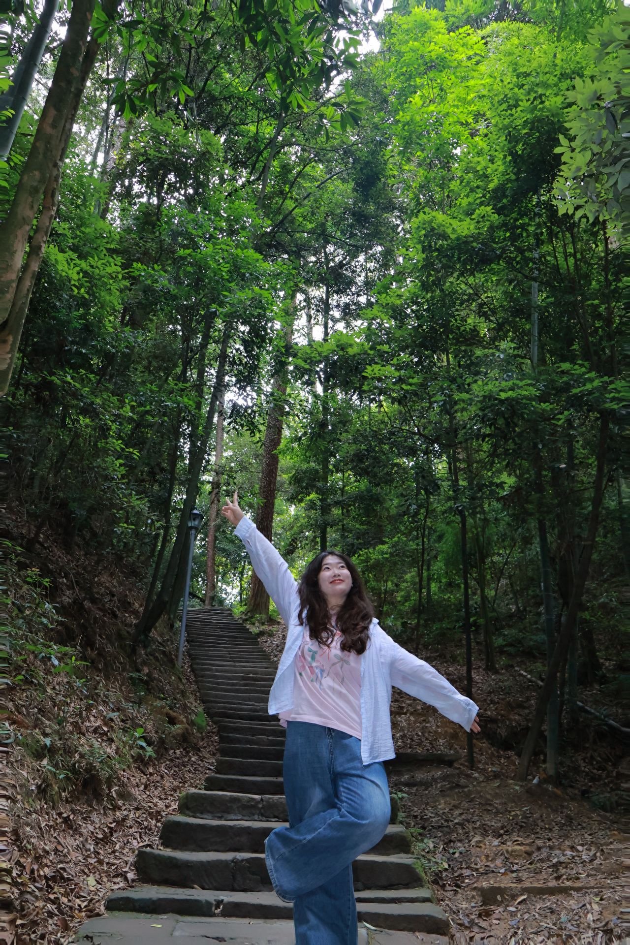 Photography Poses:

1. The model raises one leg while dramatically spreading both arms, embodying a relaxed and uninhibited pose as if embracing the mountains and forests. This conveys excitement and a strong sense of interaction with nature, showcasing vitality and passion for the environment.

2. The model naturally extends both arms, slightly tilts the head back, adopting a quieter and softer stance, as if feeling the tranquility of the mountains and forests. This creates an atmosphere of integration and immersive enjoyment with nature, conveying a sense of relaxation and contentment.

Check-in Tips:

The golden hours are from 7 to 9 AM when a thin mist lingers in the mountains and forests, and sunlight filters through the leaves, creating a dappled effect with a natural hazy filter. From 5 to 7 PM, the warm glow of the setting sun bathes the forests in a golden hue, making for exceptional backlit portraits where even the hair seems to glow.

Photography Strategy:

Position yourself in the middle or at the end of the stone steps, with the camera aligned along the direction of the steps and pointing upwards. This technique draws the viewer's focus to the person and simultaneously captures the depth and winding nature of the path, embodying the essence of "a secluded path leading to a quiet place."