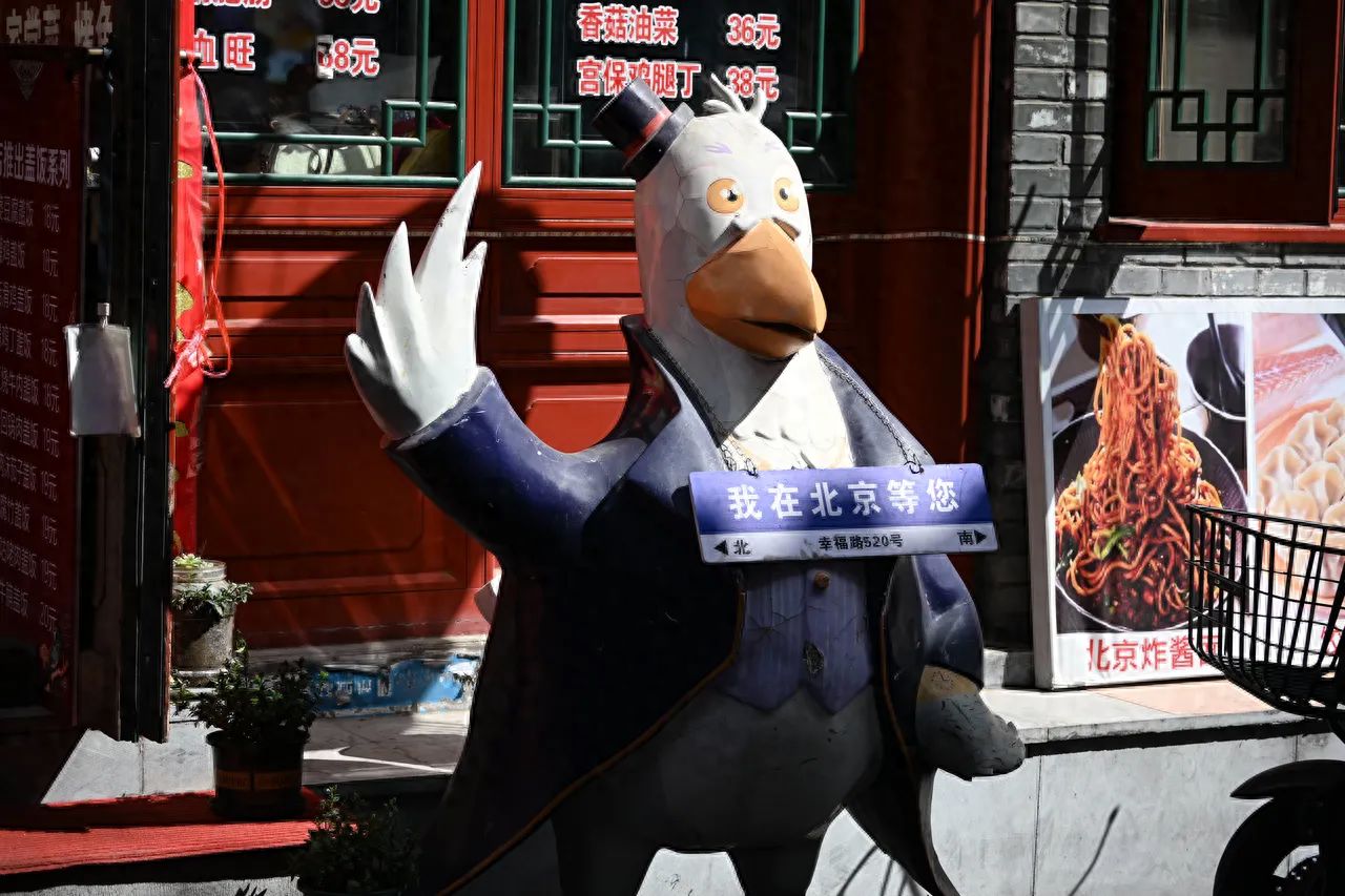 The photographer is at eye-level with the sculpture, using a central composition technique to place the sculpture in the center of the frame, highlighting the main subject while also showing the shop signs and food posters in the background, creating a street atmosphere.

Travel tips: There are many people during weekends and holidays, it is advised to avoid peak times.