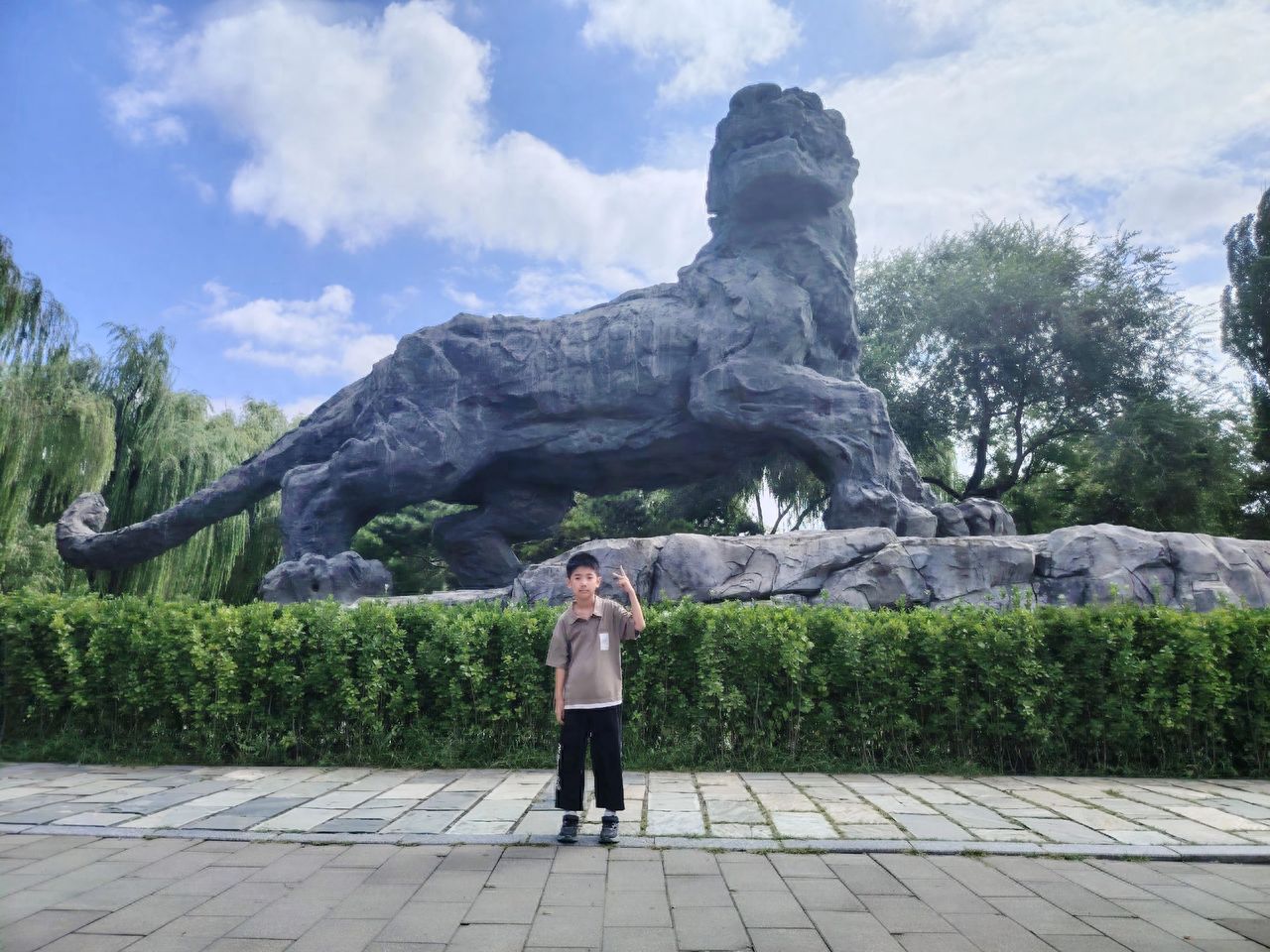 Photo by Beijing Zoo - Taking a photo with the stone lion sculpture