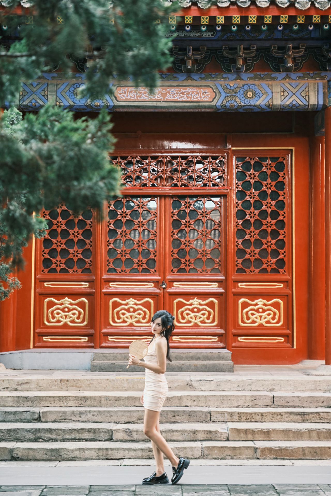 Photo by In front of the flower-shaped retro wooden door at Beijing Wanshou Temple.