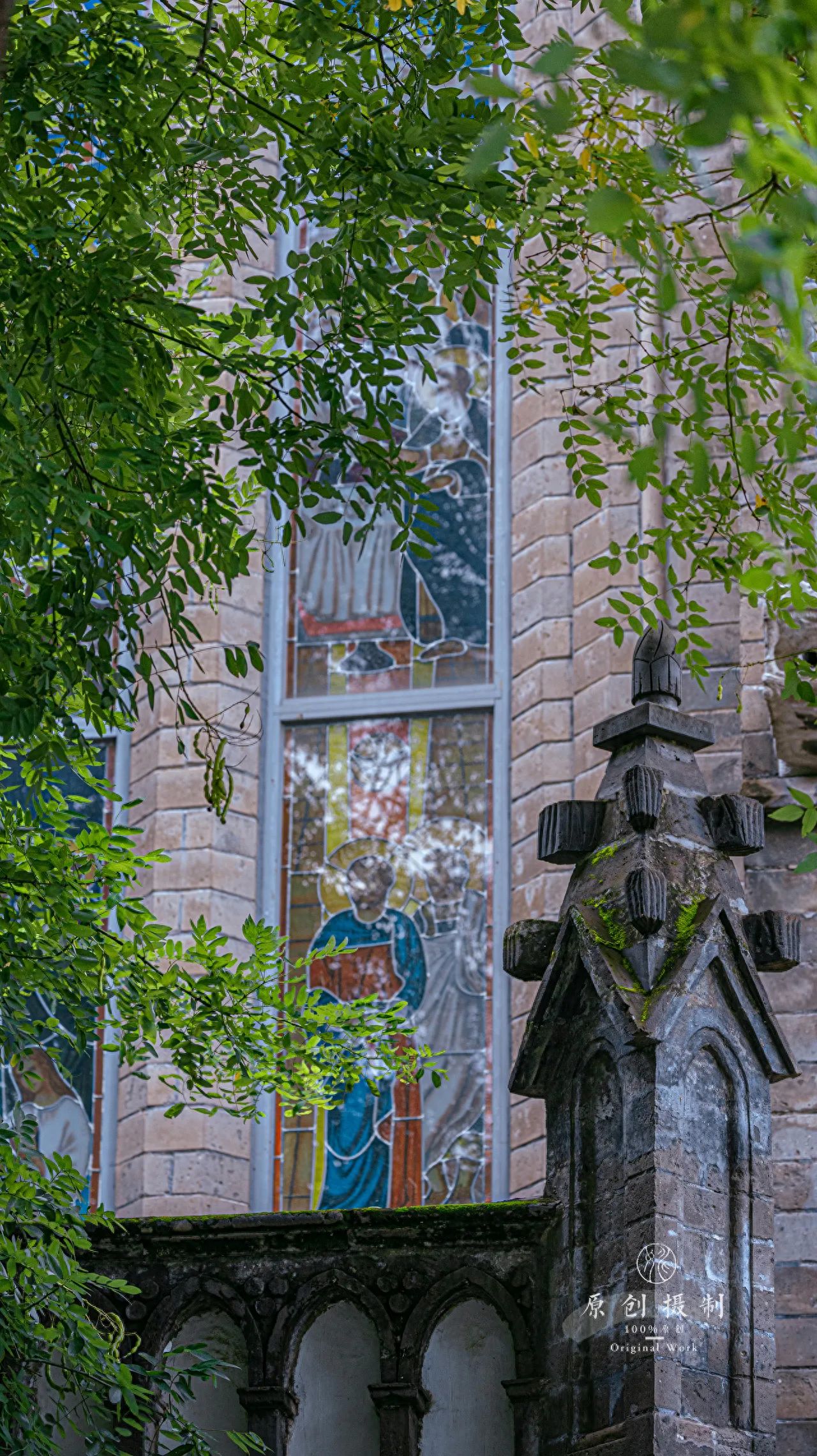 Photo by Xishiku Catholic Church - Capturing the stained glass windows and sculptures through the leaves.