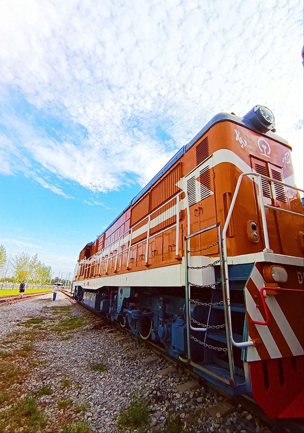Photo by China Railway Museum - Orange Locomotive Exhibit and Sky