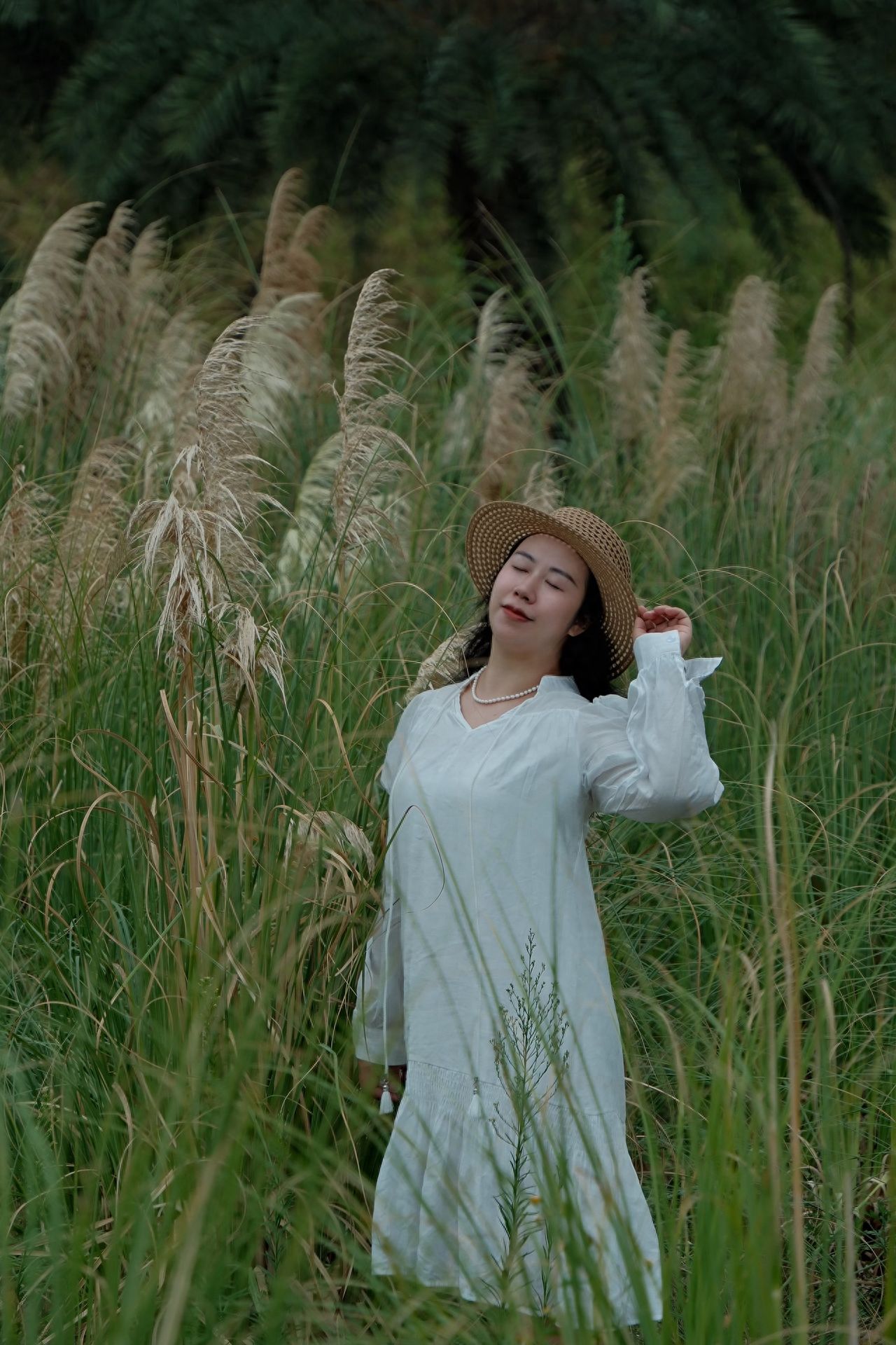 The model stands amidst the reeds, with the photographer positioned at a frontal side angle at eye level, capturing the shot straight on. A central composition is used, placing the model at the center to enhance the subject's prominence within the frame.

Travel Tips:
① Admission Fee: Free;
② Opening Hours: Open all day.