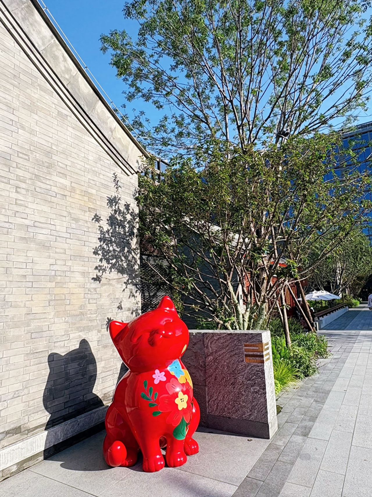 Photo by Blooming Hutong - Red Cat-shaped Sculpture and Greenery