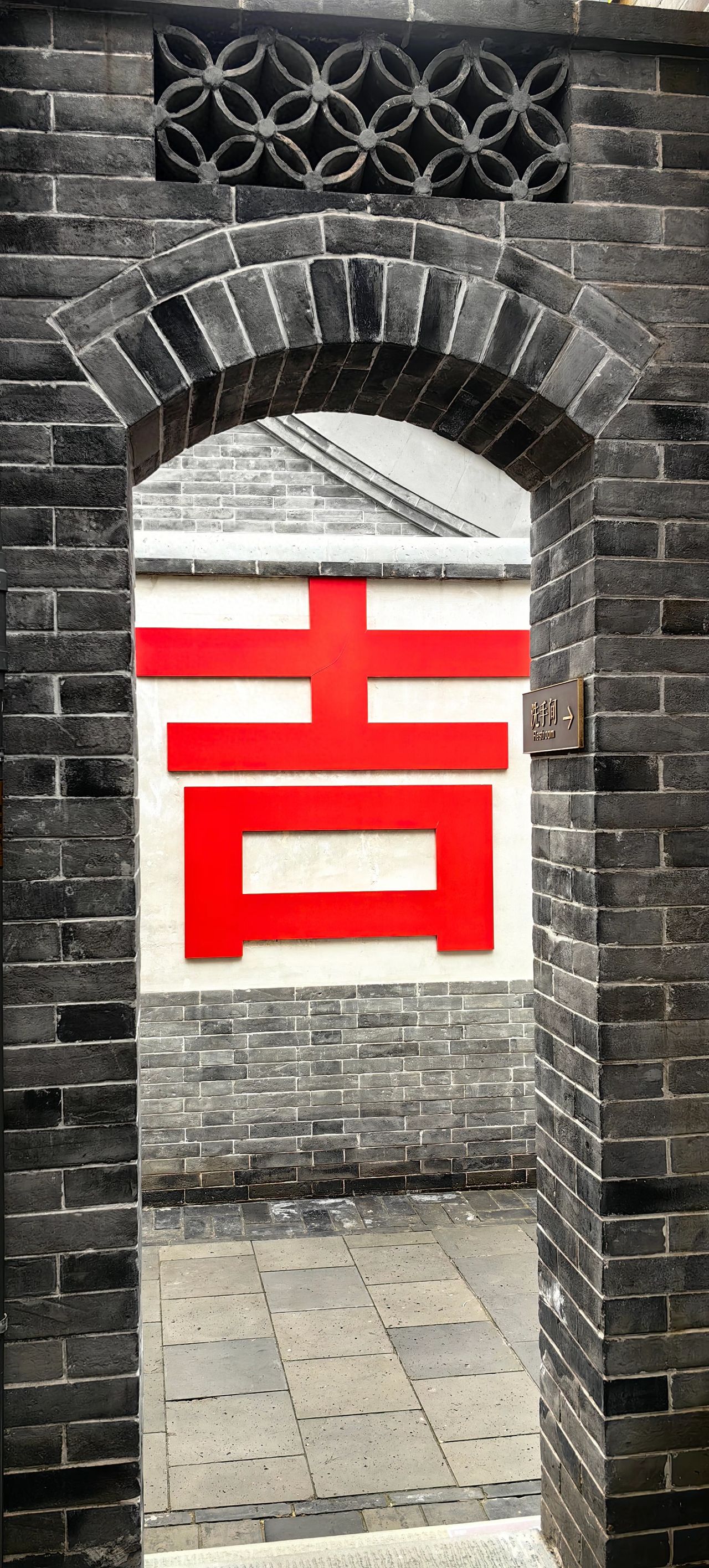Photo by Dàjí Xiàng - Capture the 'Ji' character wall through an archway.
