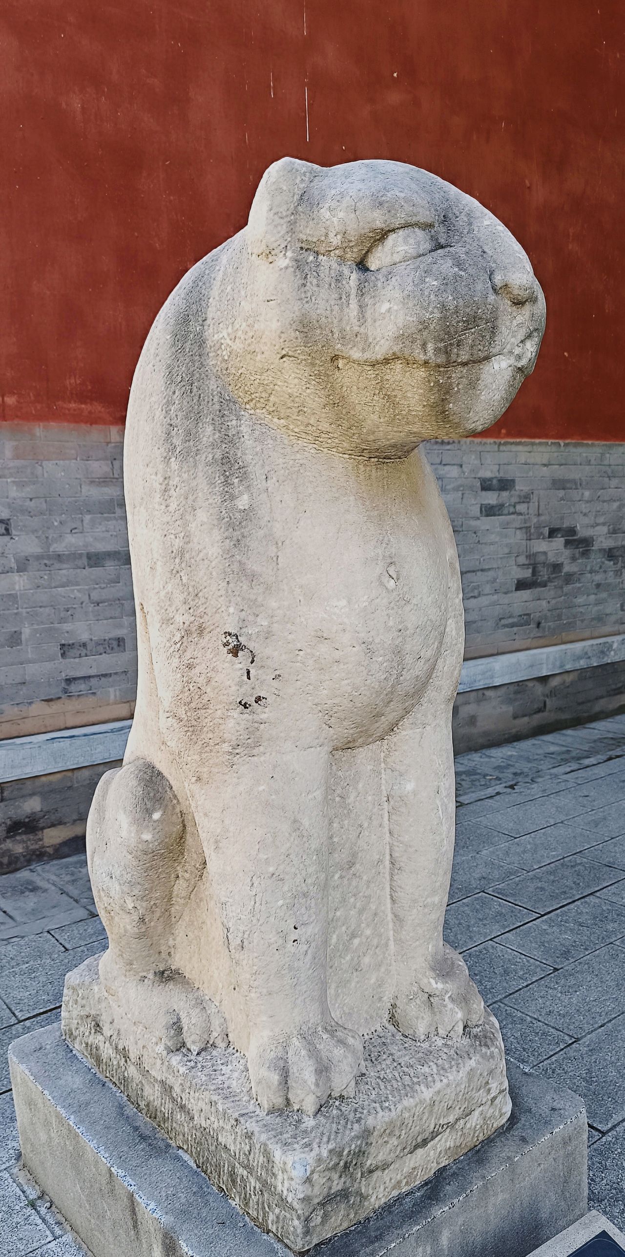 Photo by Beijing Stone Carving Art Museum - Stone Animal Statues in Front of Red Walls