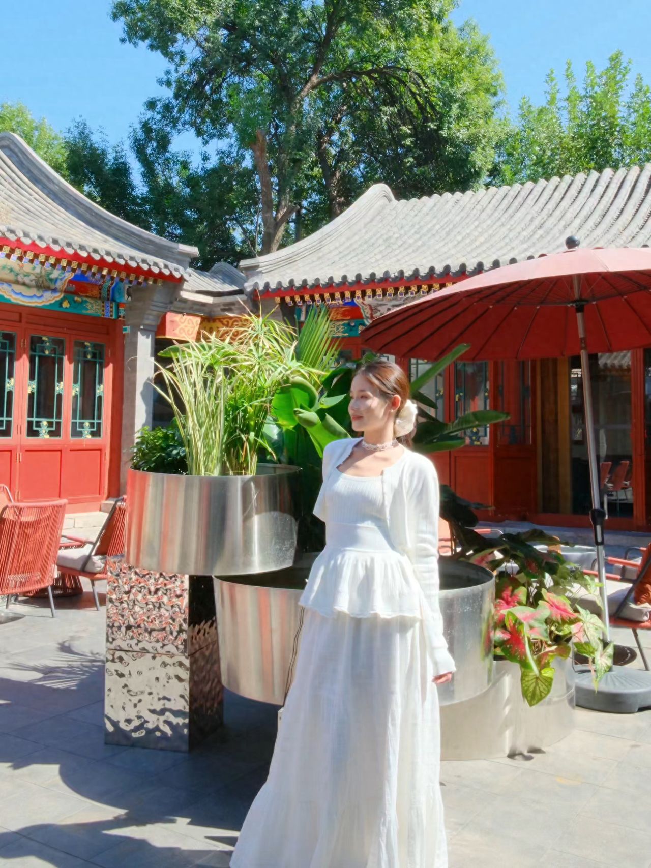 The model stands in front of the fish tank, with the photographer positioned directly in front of the model, about 4 meters away, using the vintage architecture and green plants as the background for a frontal shot.

①Photography Pose: The model faces the camera with hands crossed behind the back and face slightly turned.

②Travel Suggestion: The place is a restaurant during the day and a bar at night, with the terrace closed after 18:00.