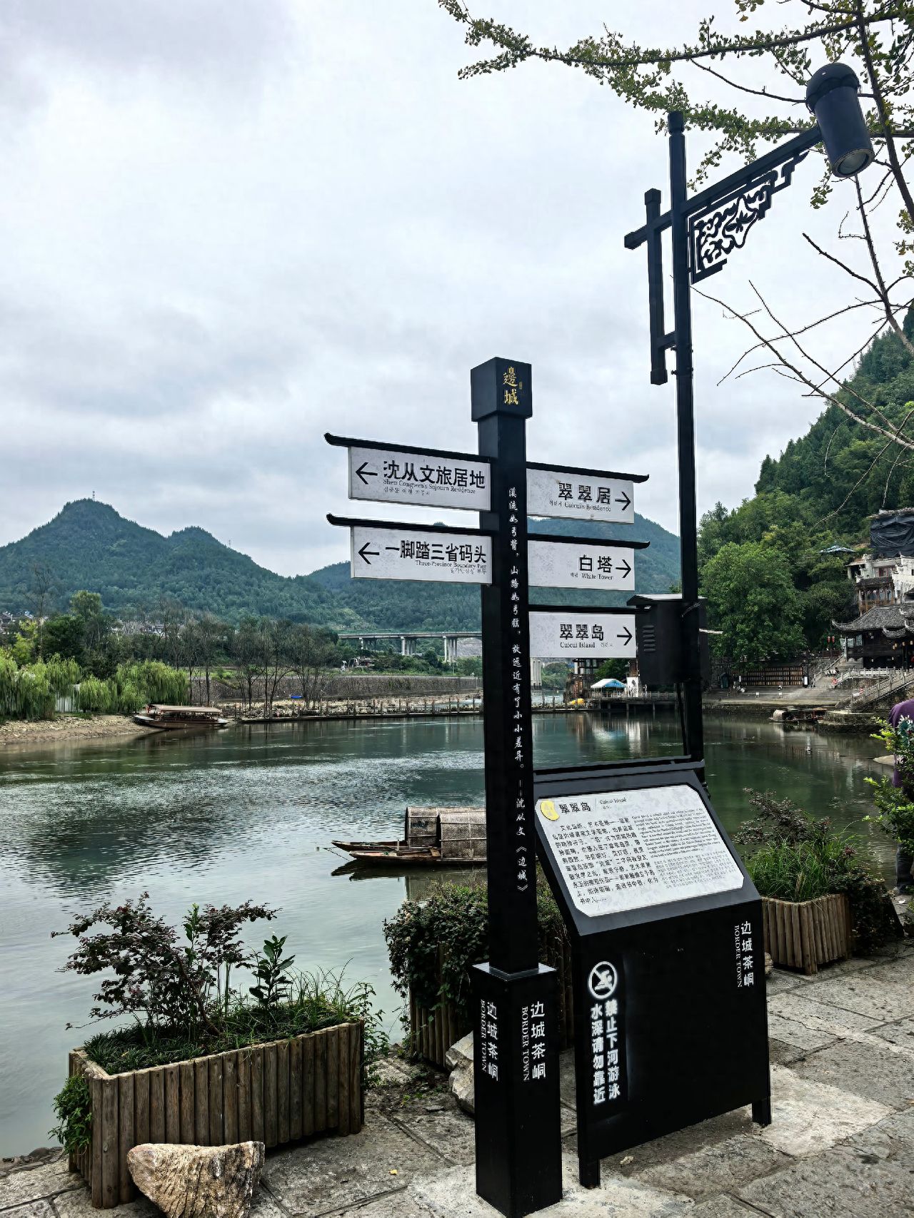 Photo by Biancheng Chadian Scenic Area - Riverside Signage Framed with Mountain View