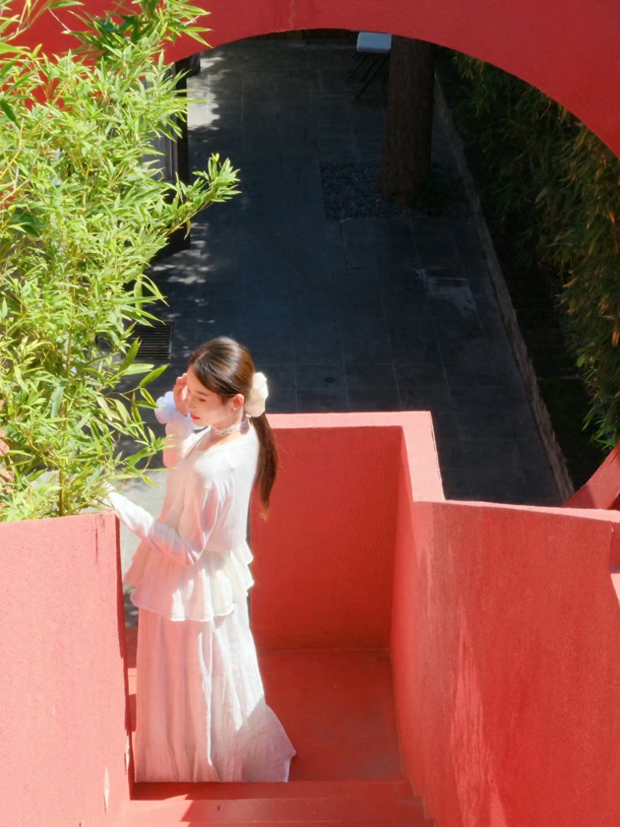 The model stands by the handrail, with the photographer positioned directly behind the model on the steps, approximately 6 meters away, using the red arch as a backdrop, shooting from a slightly elevated angle.

①Photo Pose: The model faces away from the camera, resting one hand on the railing while looking to the side.

②Travel Advice: It's a restaurant during the day and a bar at night, with the terrace closing at 18:00.