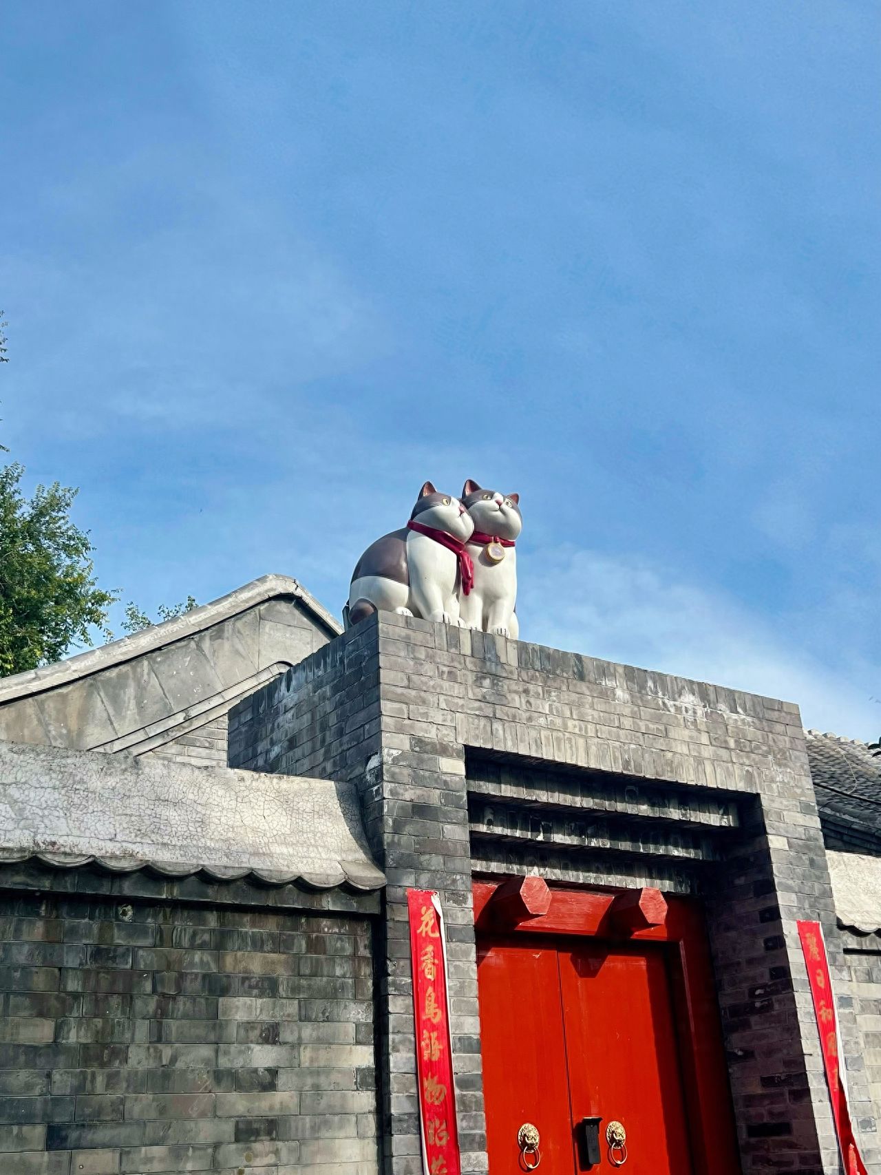 Photo by Lanman Hutong - Red Gates and Rooftop Sculptures