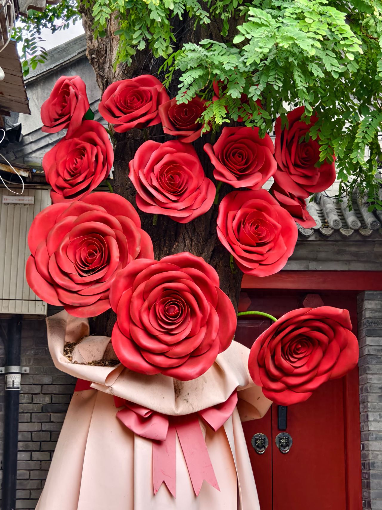 Photo by Lanman Hutong - trees decorated with large red roses