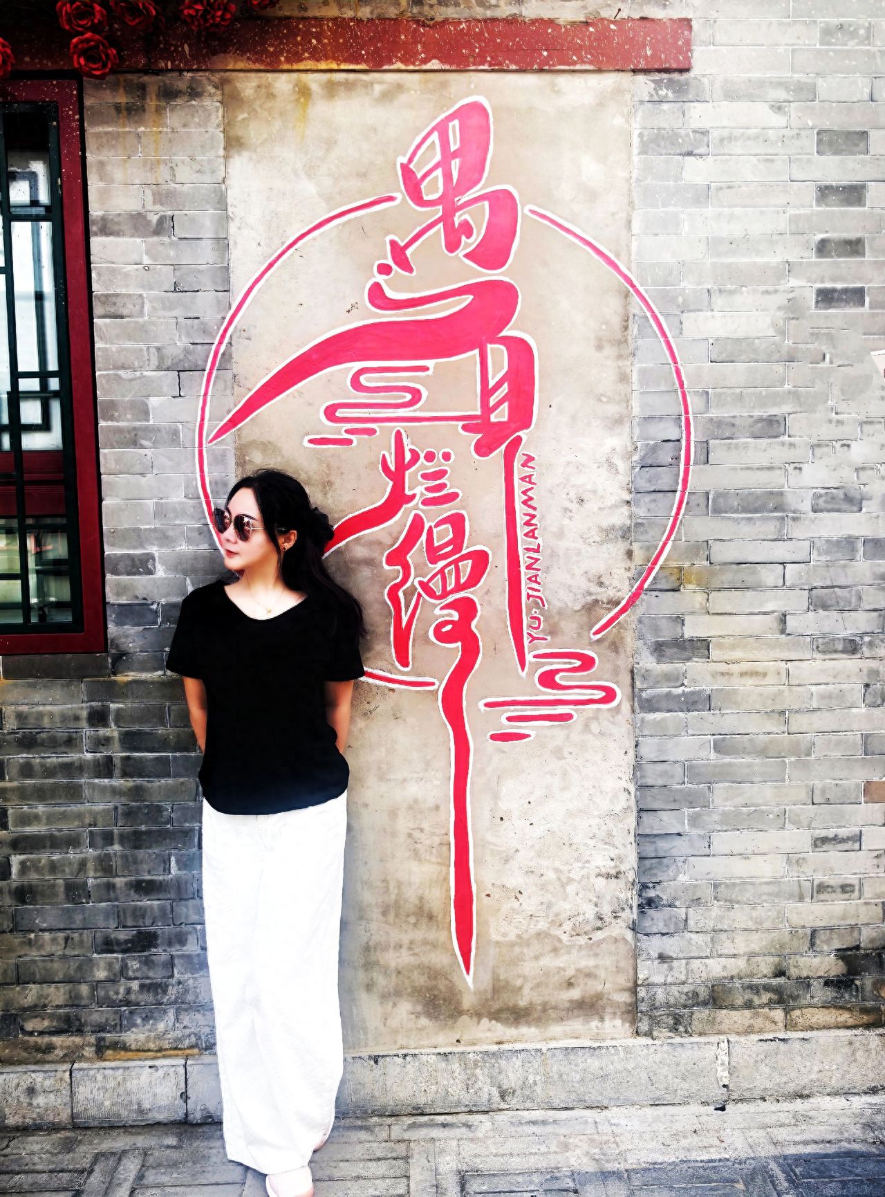 Photo by Romantic Hutong - Take a photo with the red calligraphy wall painting on the brick wall and window.