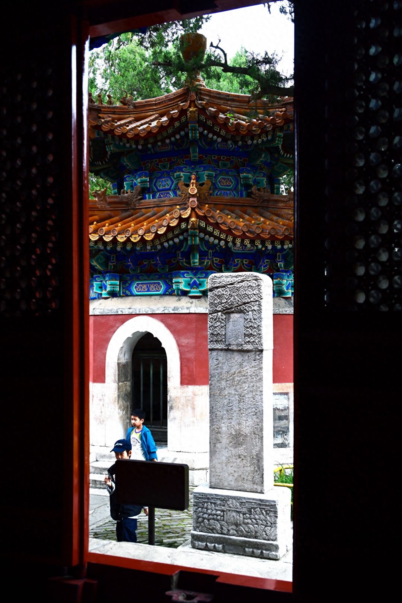 Photo by Fragrance Hill Biyun Temple - Capturing the stone stele and architecture through the door frame.