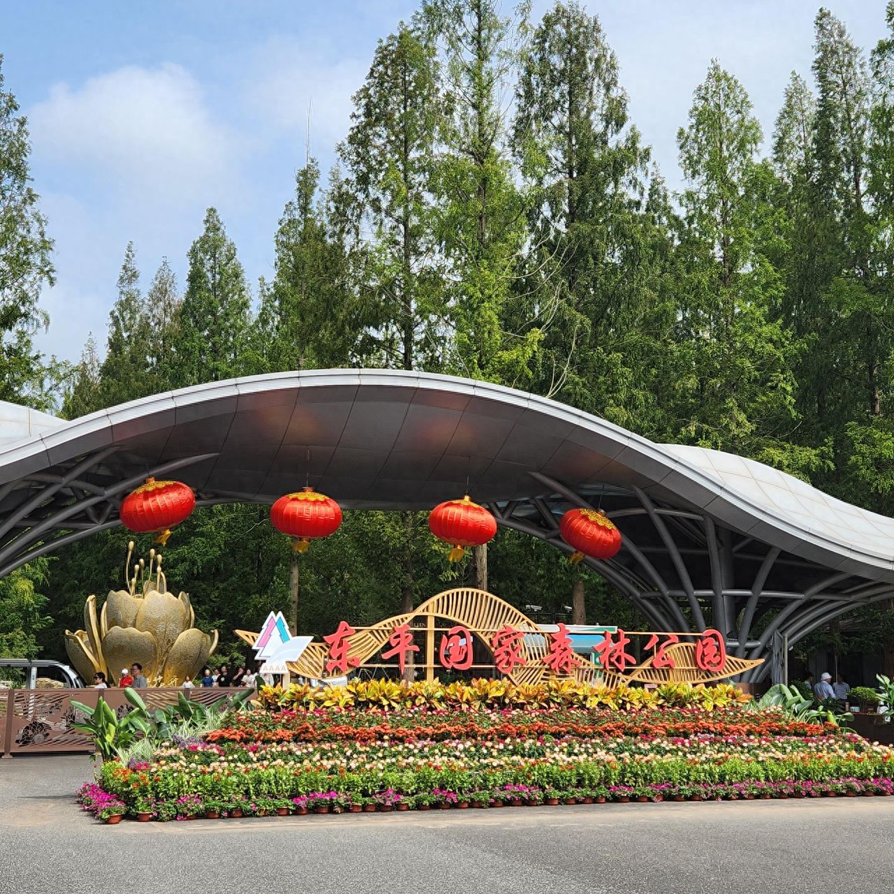 Photo by Dongping National Forest Park – Entrance Sign, Lanterns, and Flower Bed