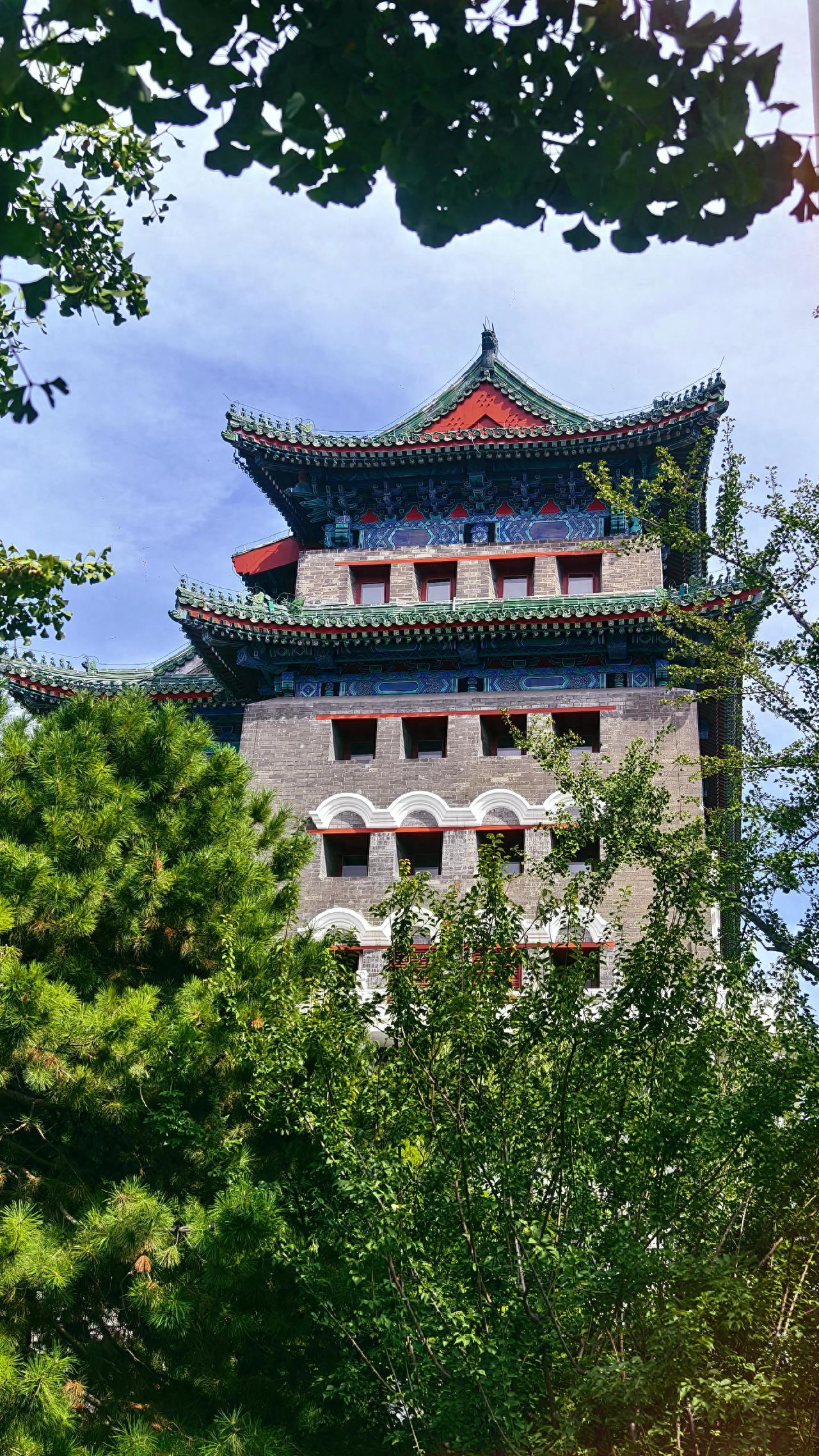 Photo by Zhengyangmen Arrow Tower - Multiple window lattices under the eaves of the building and trees.