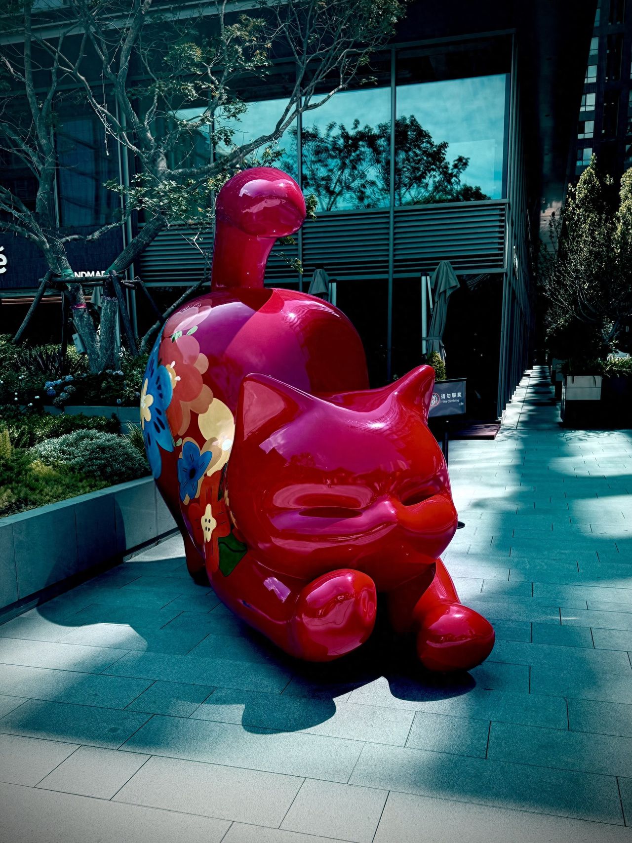 Photo by Daji Alley - Red Cat Sculpture on Stone Slab Path