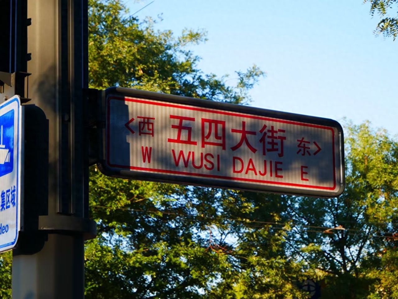 Photo by Beijing May 4th Street - Red Signage and Trees