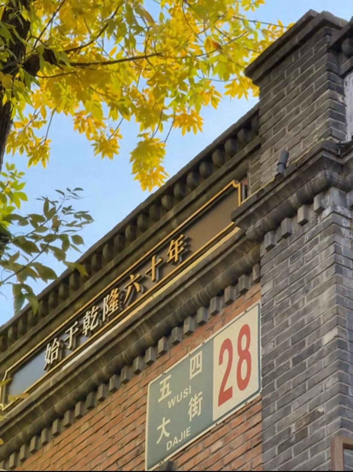 Photo by Beijing May 4th Street - Tree Branches and Brick Wall Building Sign