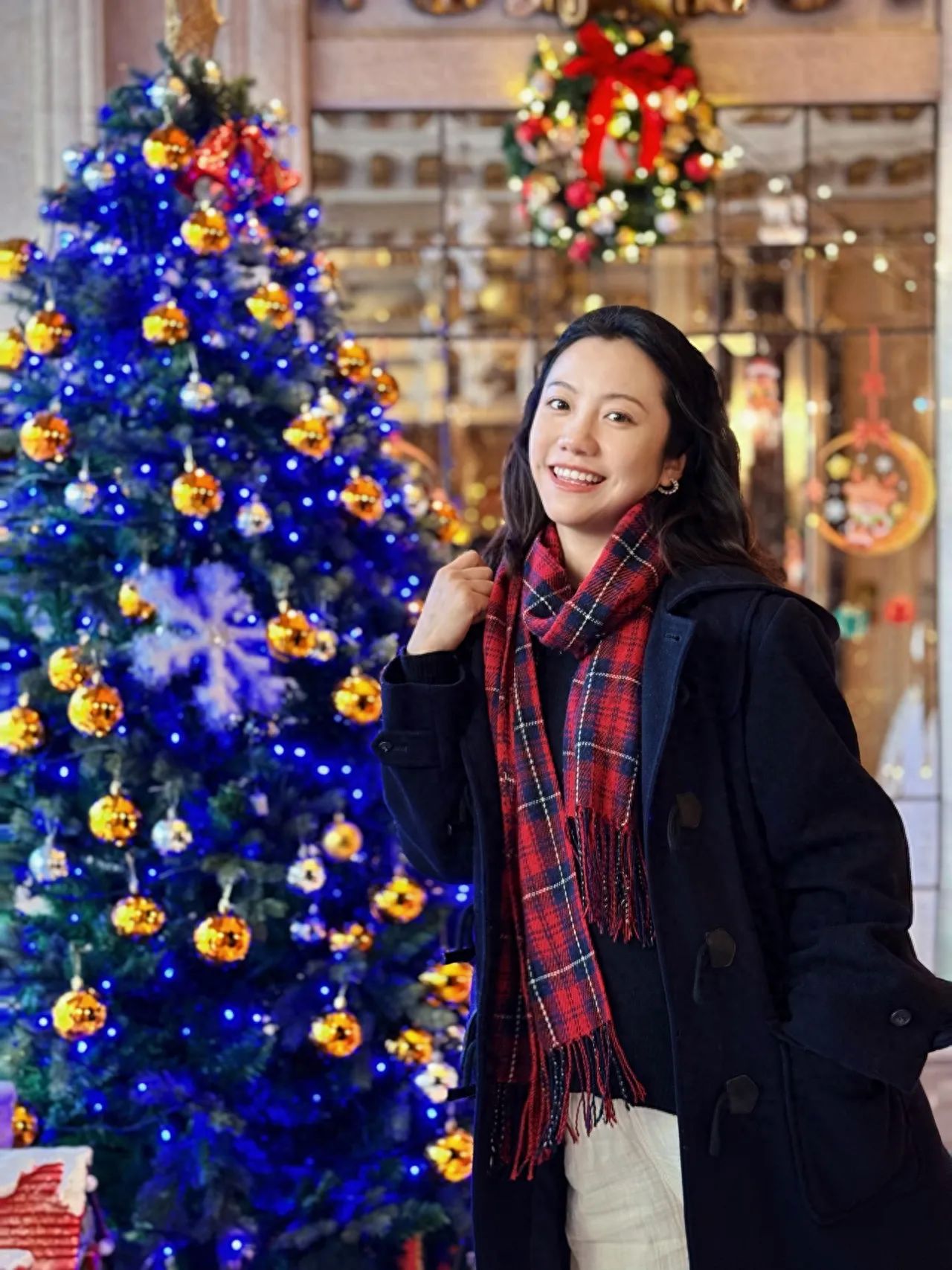 1. Angle of view: The photographer stands at the side front of the subject, shooting at eye level.
2. Composition technique: Employ a frame-within-a-frame composition, using the shop window and Christmas wreath in the background as framing elements to draw the viewer's attention to the person and the Christmas tree.
3. Lens suggestion: Use the 2x telephoto portrait mode to focus on the person's face, blurring the Christmas tree to make the model the focal point of the image.
Photo pose: The model stands in front of the Christmas tree, either facing forward or sideways.
