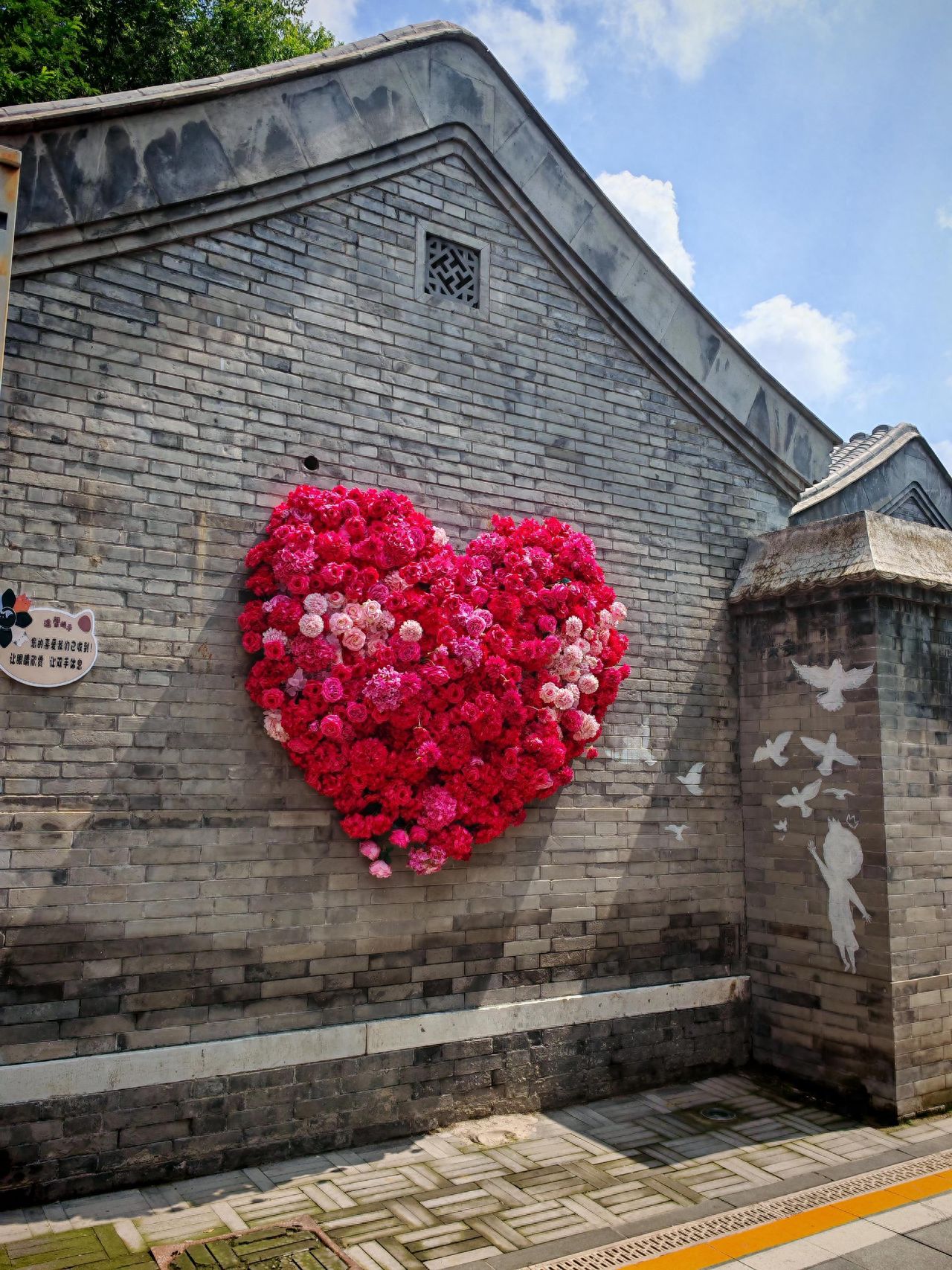 Photo by Lanman Hutong - Heart-shaped Rose Flower Decorated Brick Wall