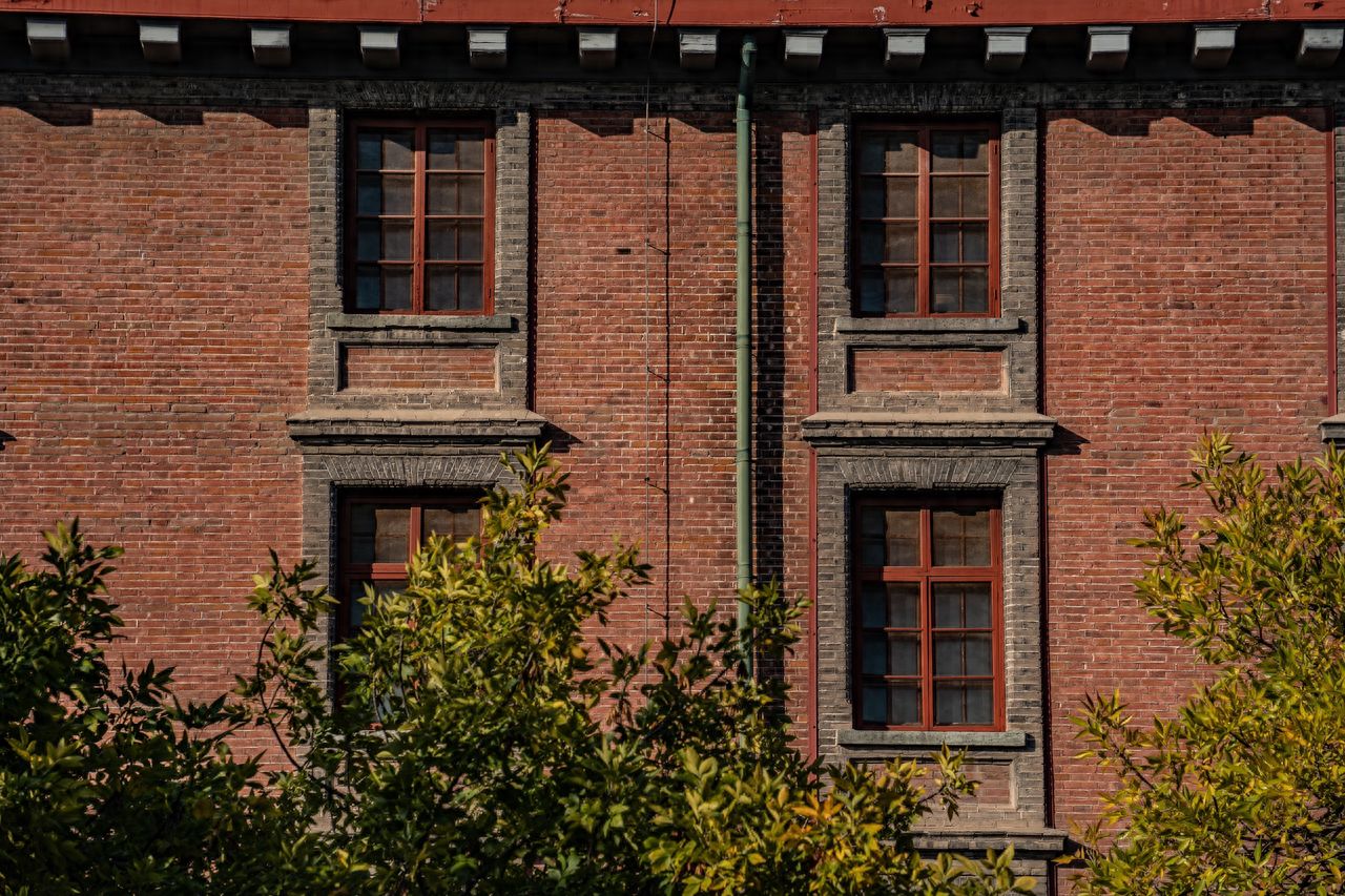 Photo by Beijing May 4th Street - Close-up of red brick building windows and trees