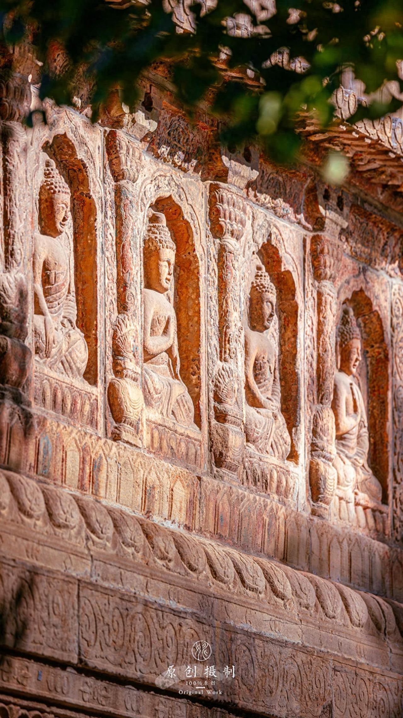 Photo by Beijing Stone Carving Art Museum - Close-up of the Buddha Relief on the Pagoda Face with Greenery