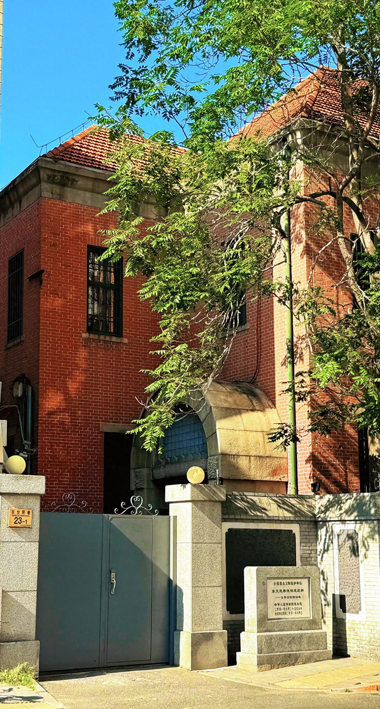 Photo by Dongjiaomin Alley – Red Brick Building Entrance and Stele