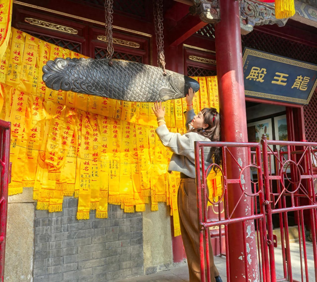 Photo by Tanzhe Temple - Take a photo with the Dragon King Hall stone fish and prayer cloth strips.