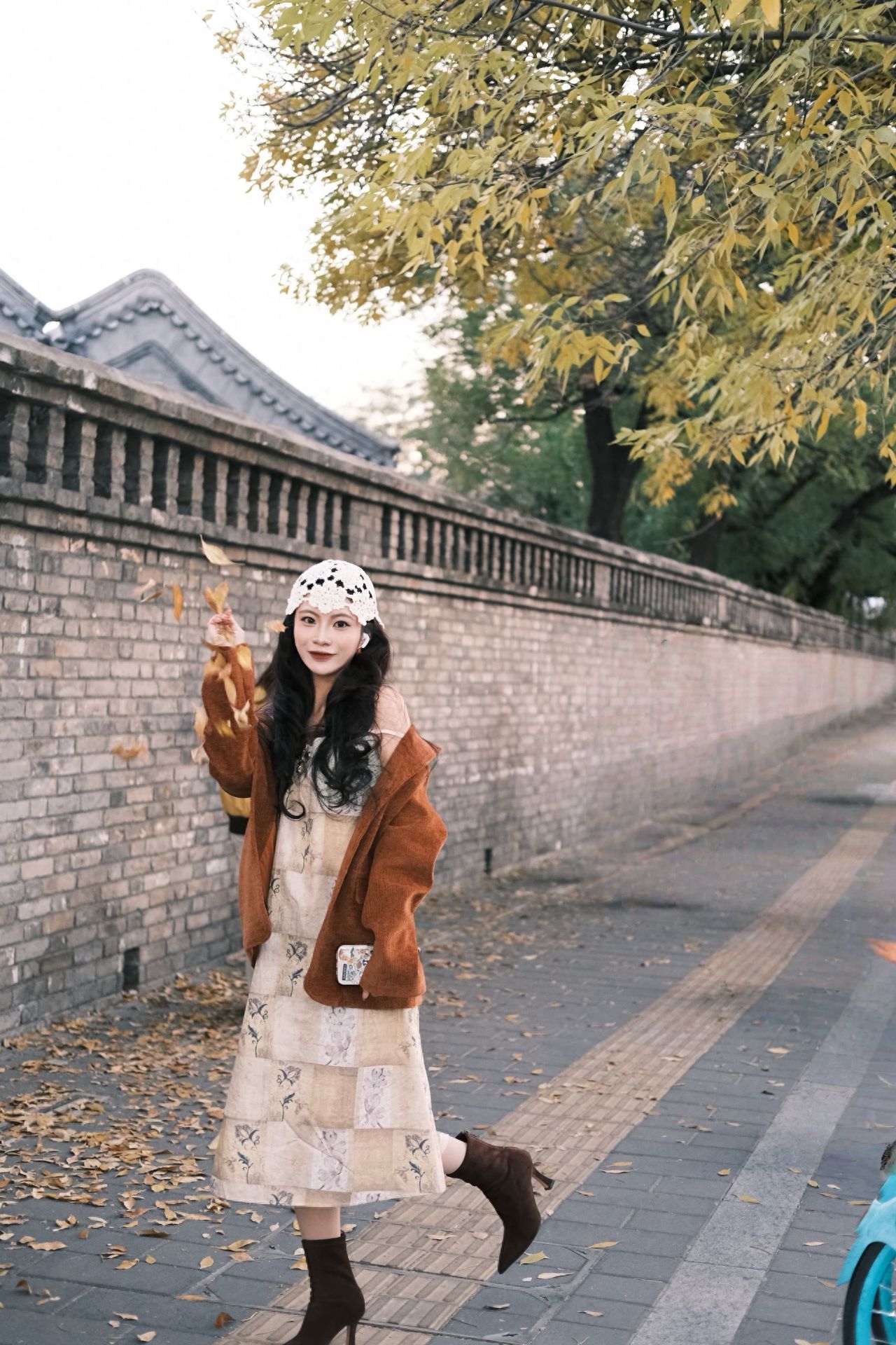 Photo by Beijing May 4th Street - Take a photo with the brick wall and autumn leaves.