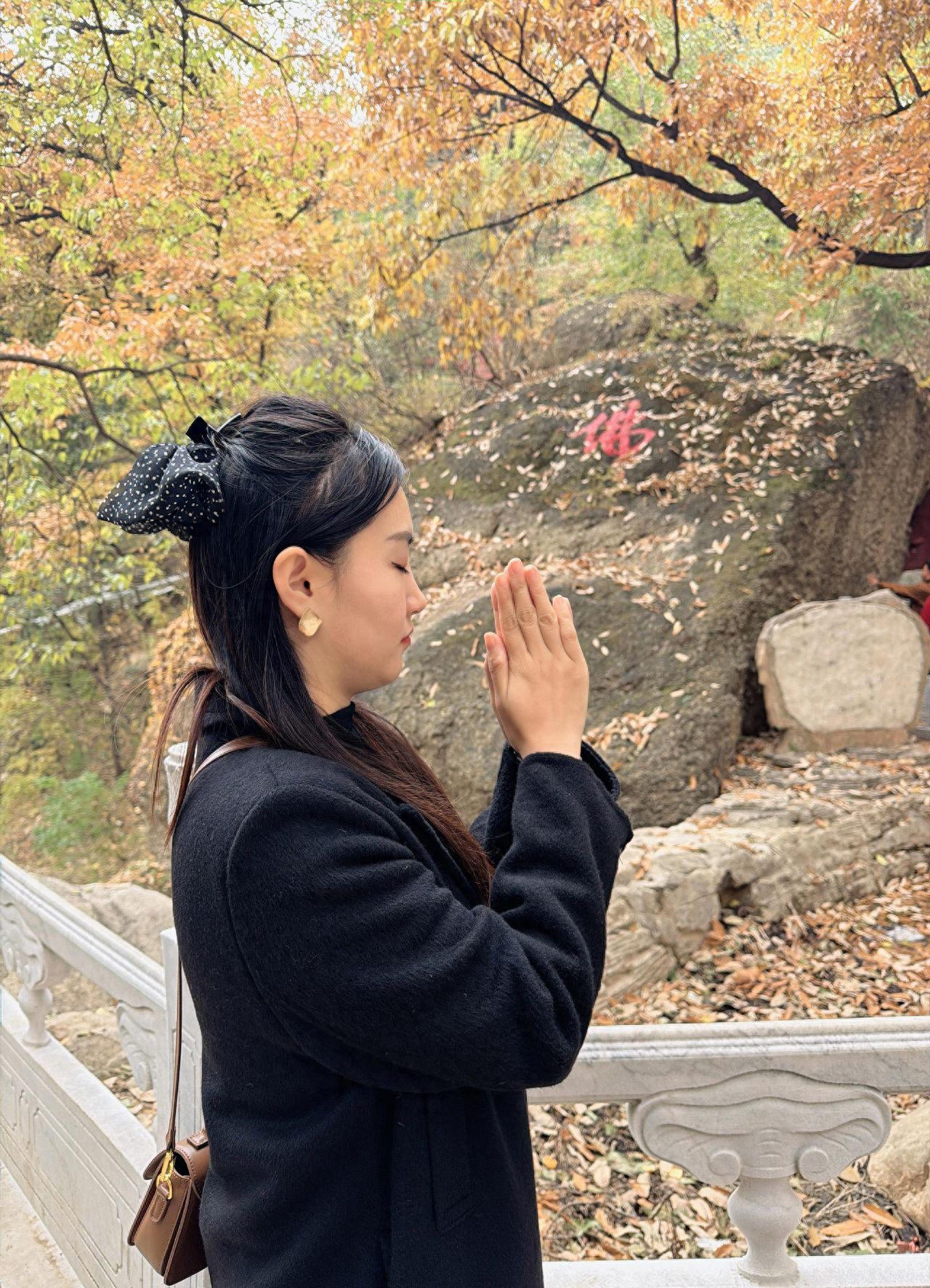 Photo by Tanzhe Temple - Take a photo with the Buddha inscription, railings, and mountains in the background.